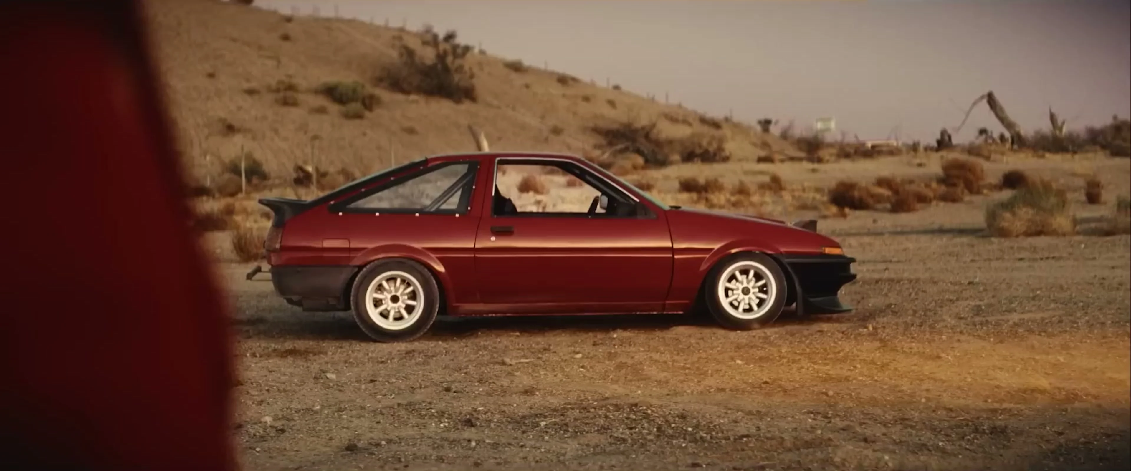 A red Toyota AE86 called Lola stands in the desert in Drifter.