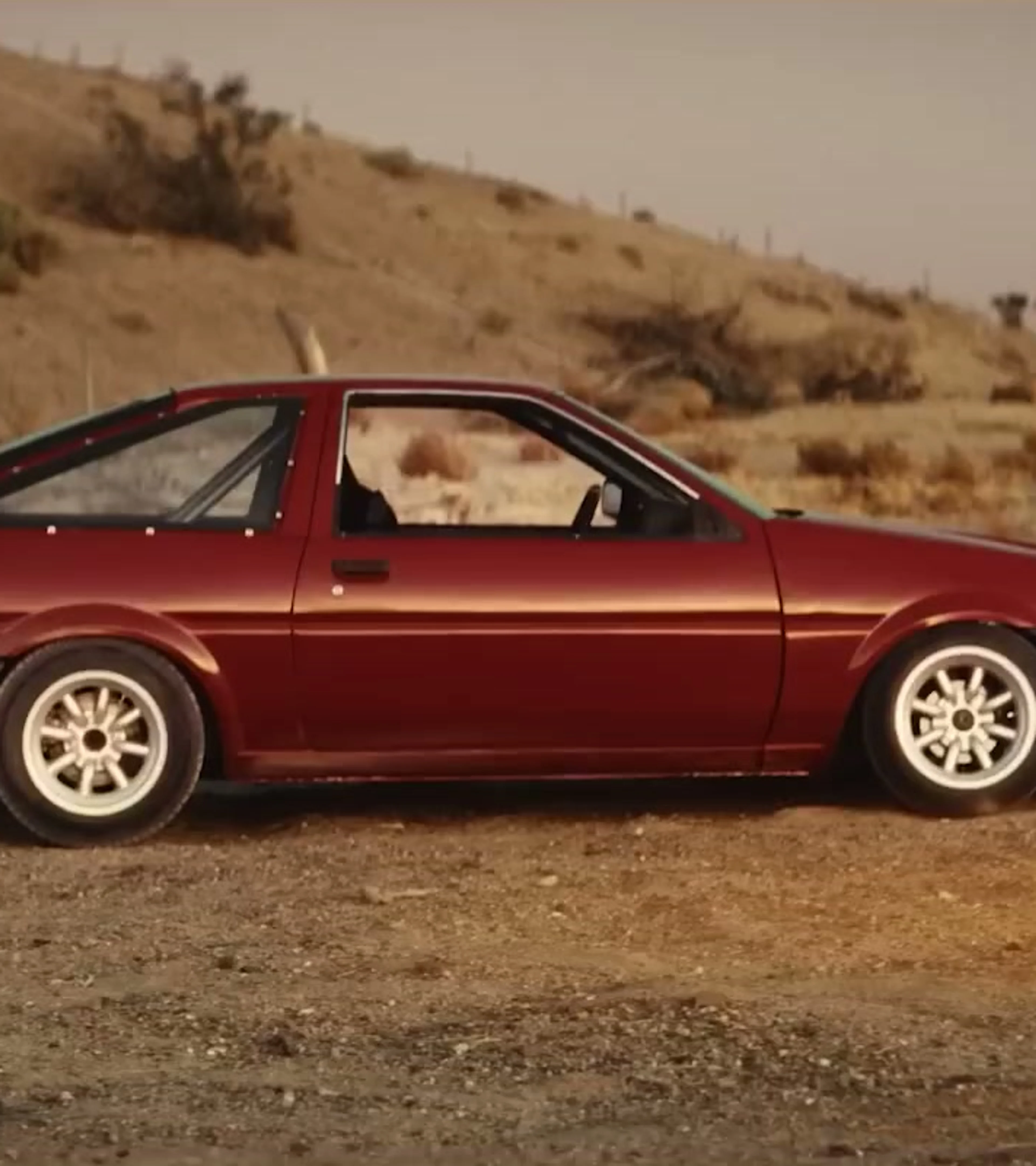 A red Toyota AE86 called Lola stands in the desert in Drifter.