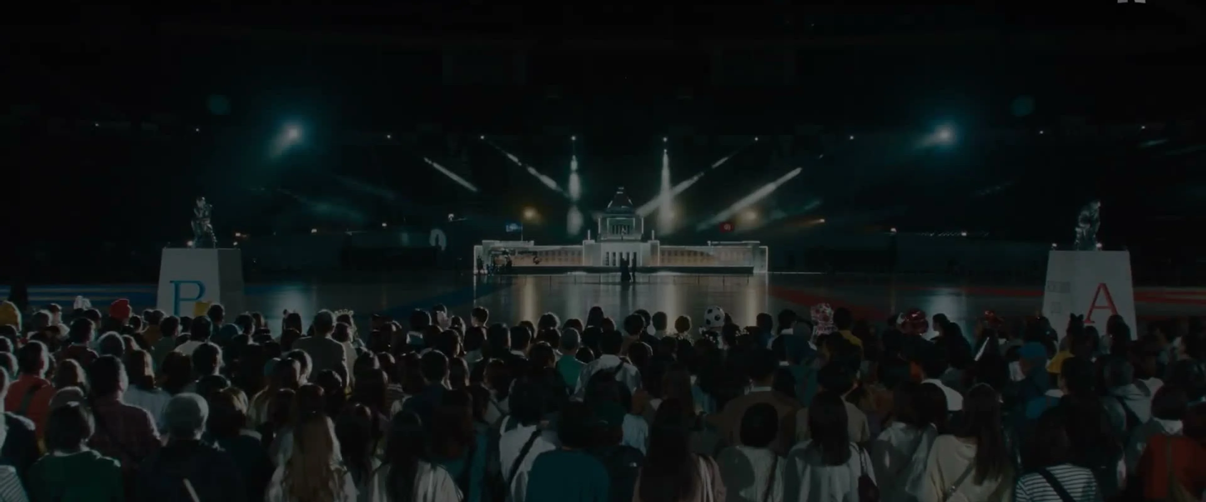 A crowd faces the brightly lit Quiztopia television stage.