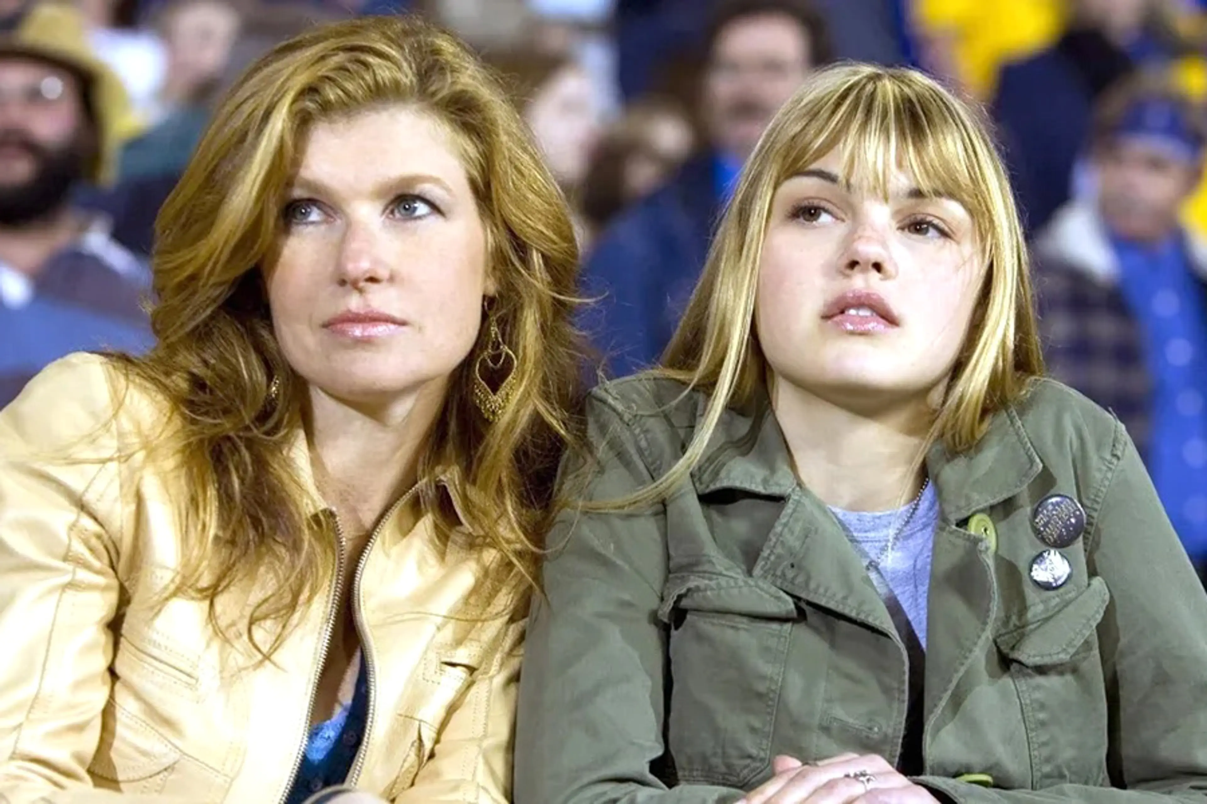 Connie Britton and Aimee Teegarden as Tami and Julie Taylor sit in stadium seats in Friday Night Lights.