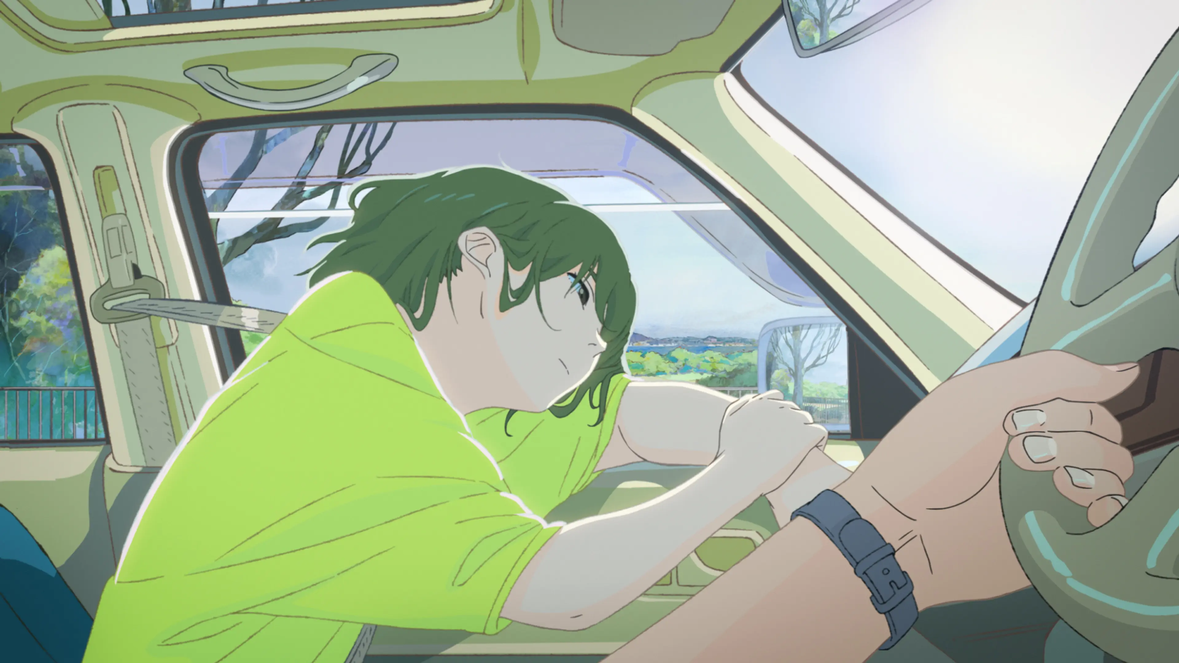 Kaoru leans forward inside a car while a hand holds the steering wheel.