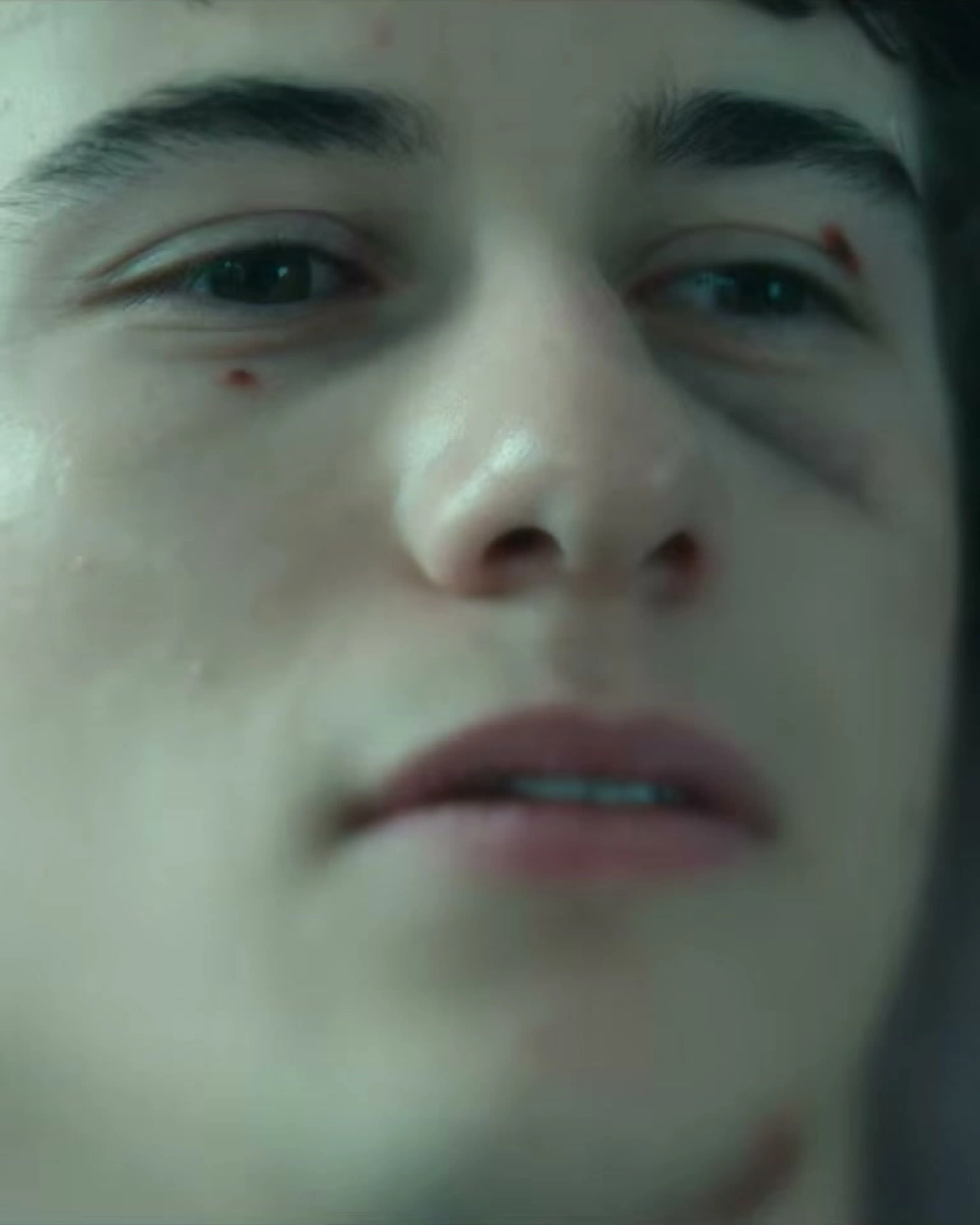 A teenager looks up in a close-up from the Phony trailer.