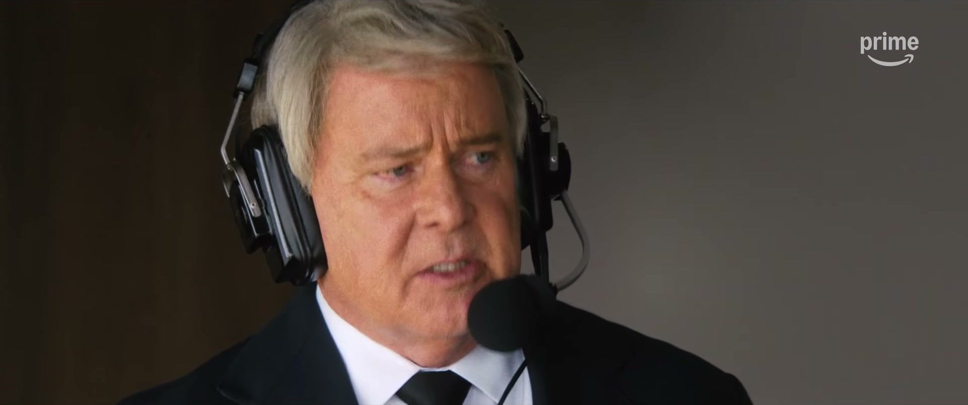 Nicolas Cage as John Madden wears a headset in a commentary booth.