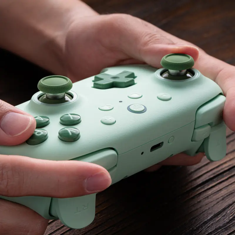 Green 8BitDo Ultimate 2C Wireless held in two hands, showing its buttons and USB-C port