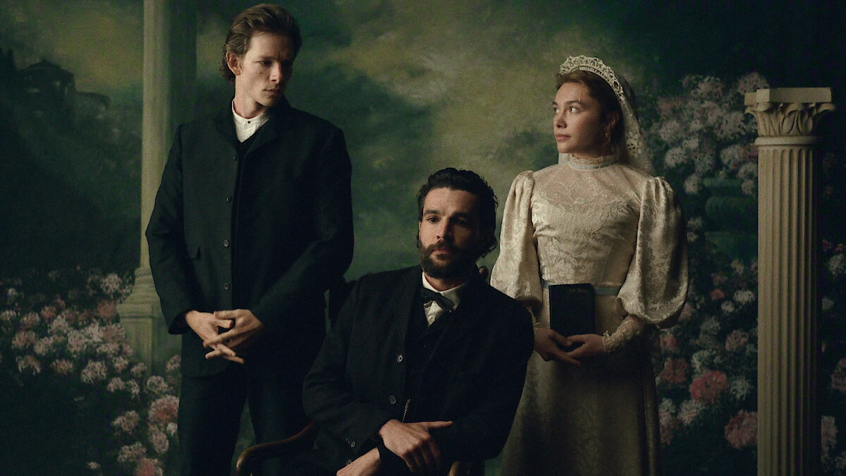 Mike Faist as Charles stands beside Christopher Abbott as Adam, seated, and Florence Pugh as Cathy in a posed period portrait.