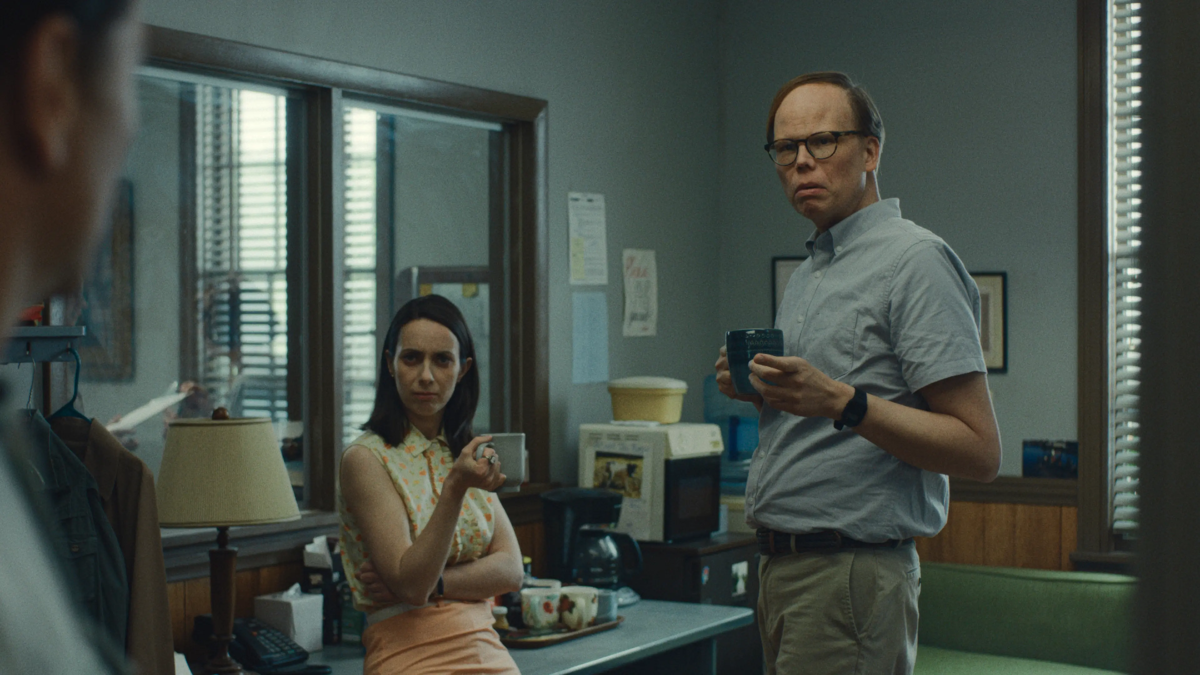 Kate O’Flynn and Jeff Hiller hold cups in a room at the town office.