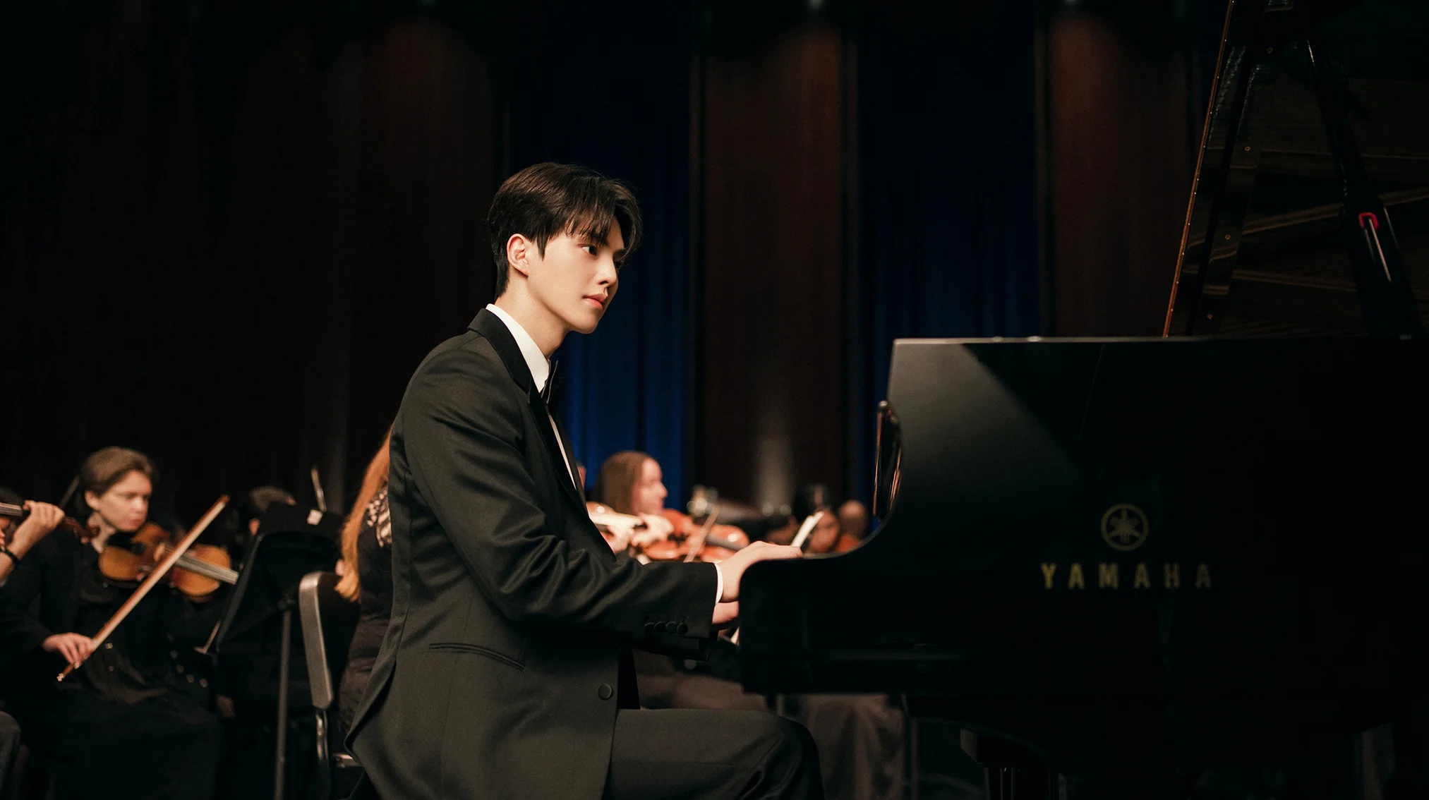 A young pianist performs beside an orchestra in Four Hands, Two Sonatas.