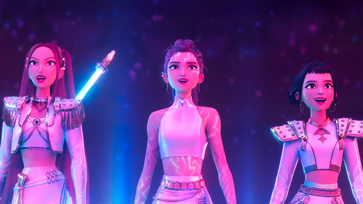 Mira, Rumi, and Zoey perform together under pink and blue stage lights in KPop Demon Hunters.
