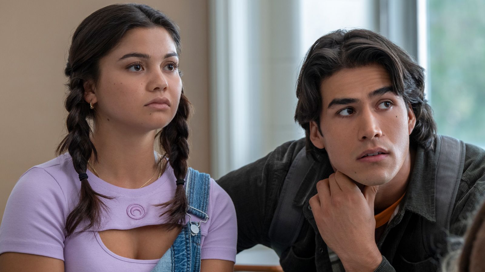 Siena Agudong as Sue Snell and Joel Oulette as Tommy Ross sit beside each other in a classroom.