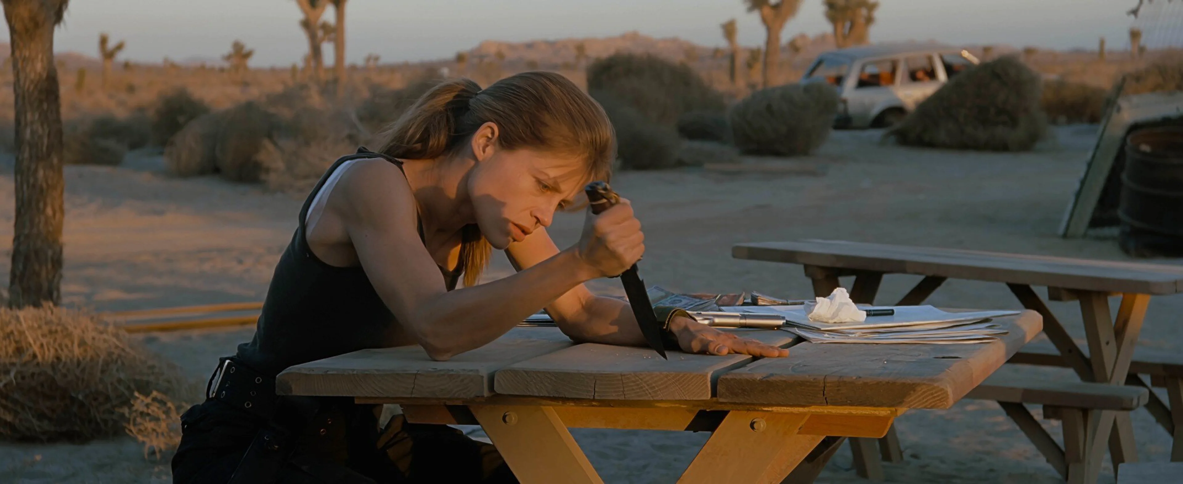 Linda Hamilton as Sarah Connor drives a knife into a picnic table in Terminator 2: Judgment Day.