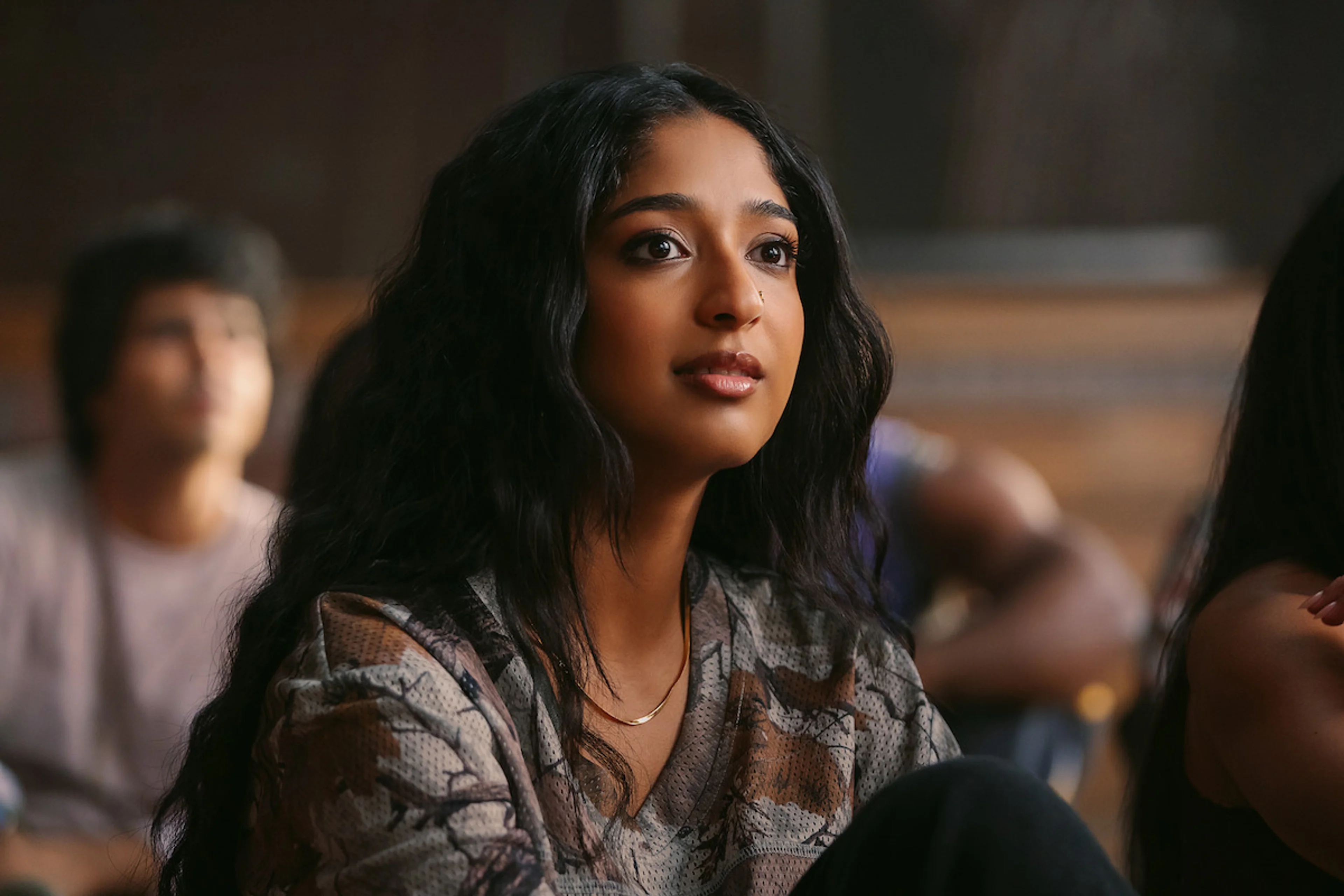 Maitreyi Ramakrishnan listens intently in a college classroom scene.