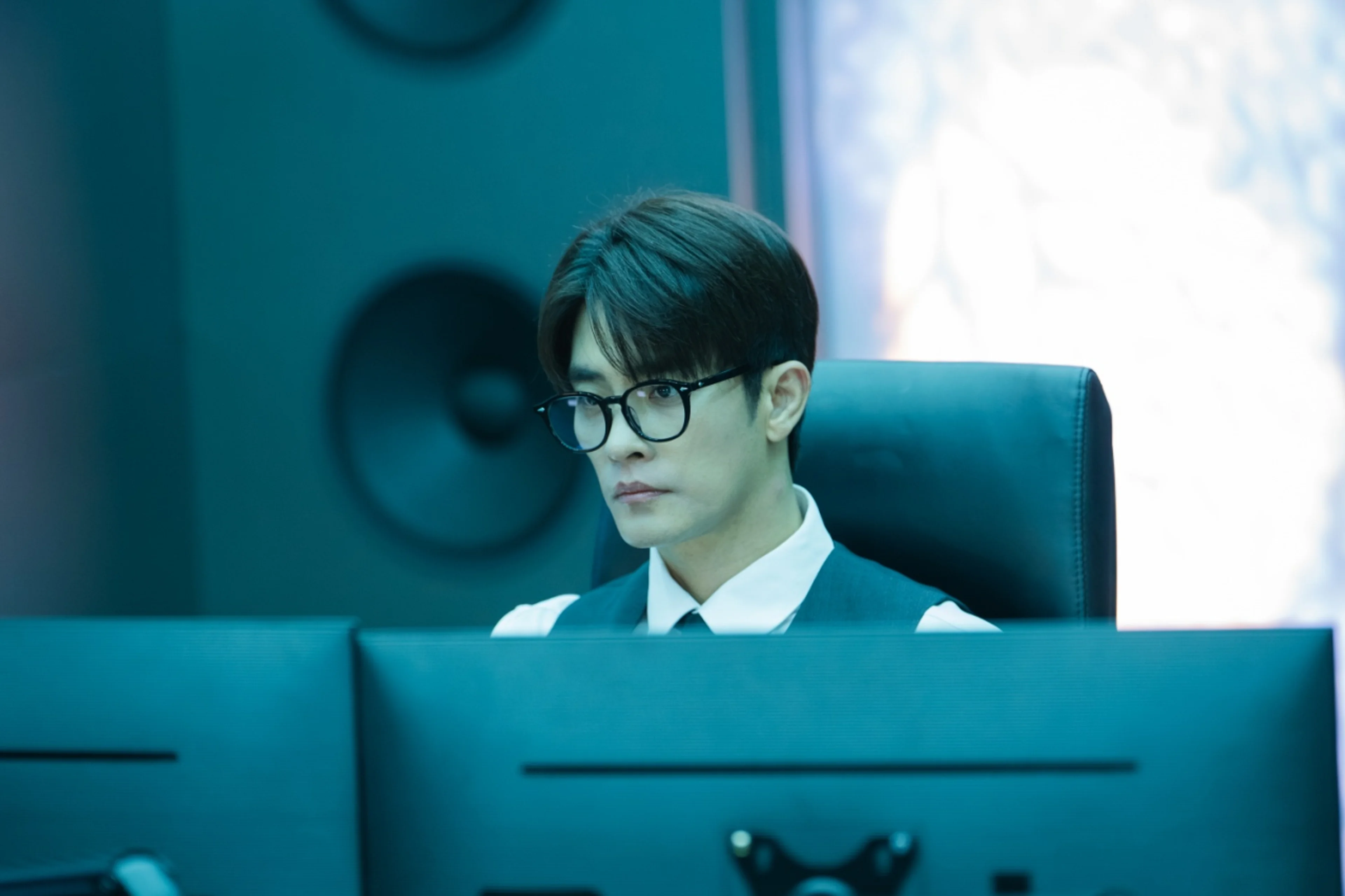 Sung Hoon as Kwon Do-hyuk sits behind a computer wearing glasses in What a Boss Wants.