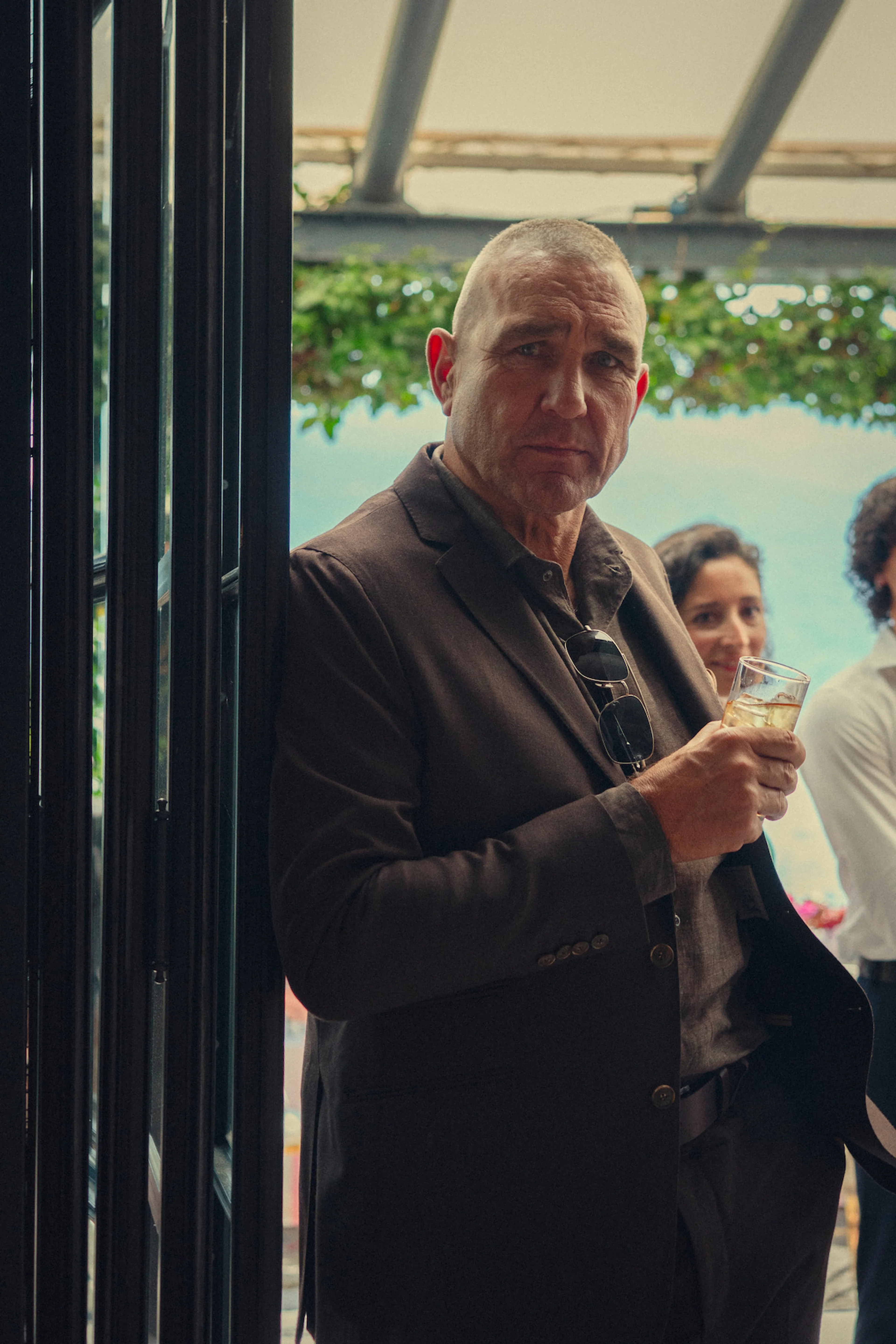 Vinnie Jones poses in a brown suit during promotion for The Gentlemen Season 2.