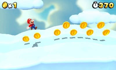 Mario jumps over white cloud platforms and a curved line of gold coins.