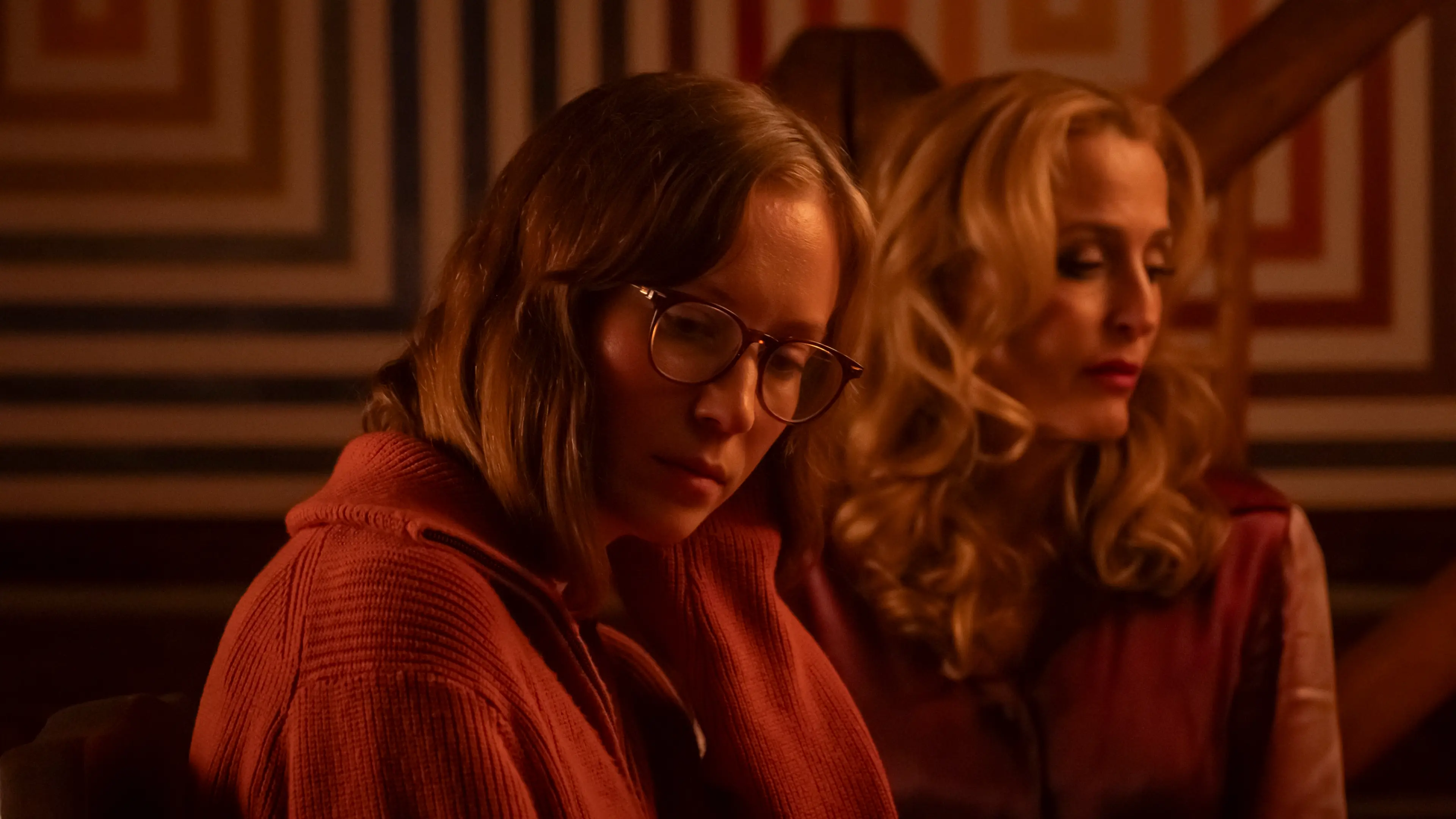 Hannah Einbinder as Kris and Gillian Anderson as Billy sit together in a warmly lit room.