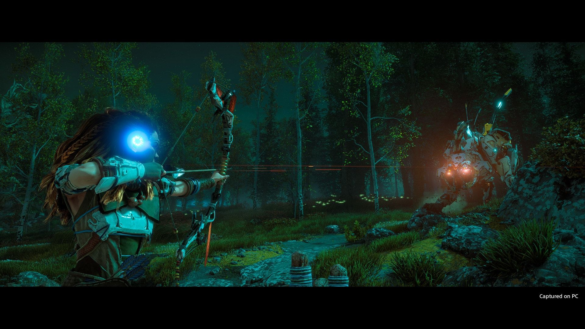 Aloy aims her bow toward a glowing machine in a dark forest.