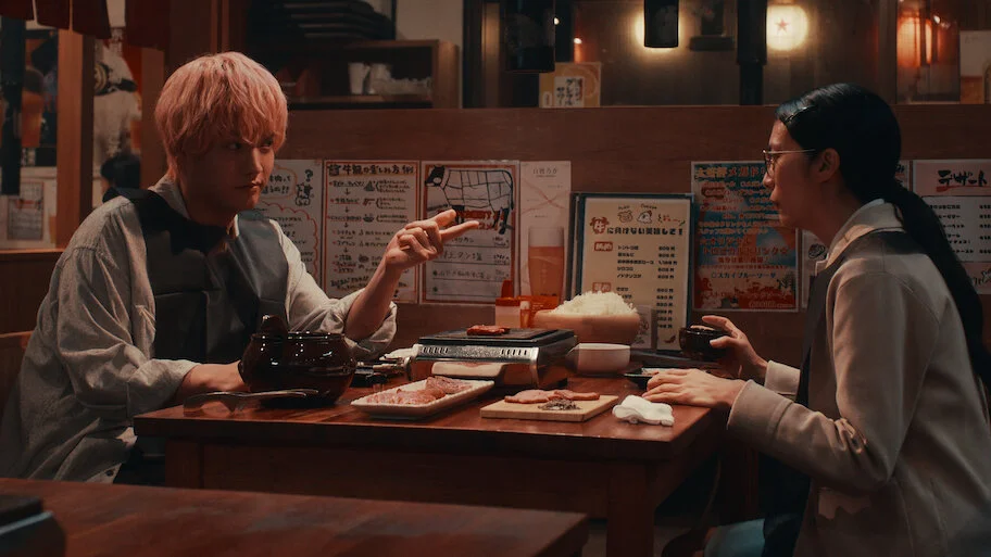 Yui and Sena sit together during a scene from the Japanese romance film.