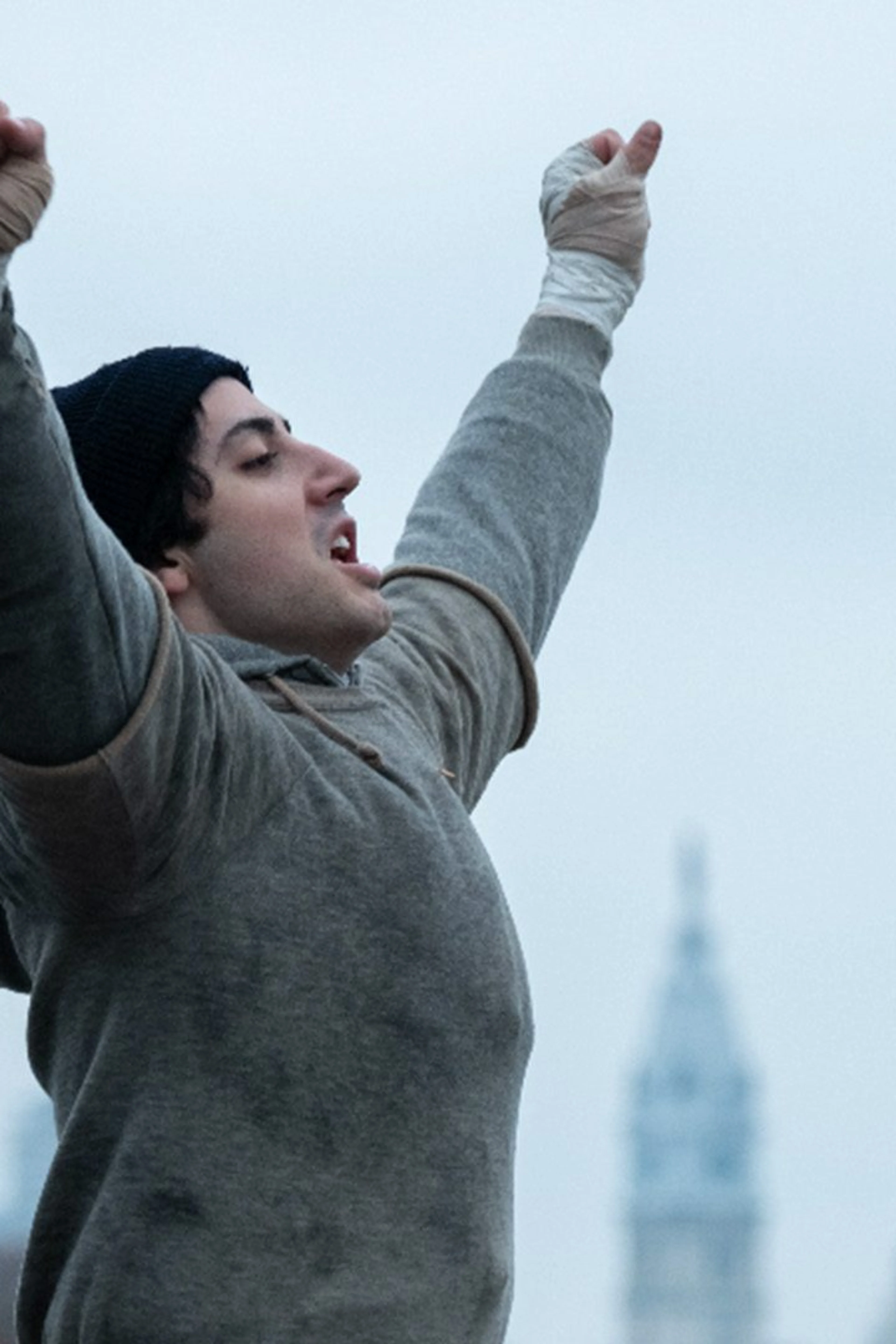 Anthony Ippolito as Sylvester Stallone raises his wrapped hands in an official I Play Rocky still.