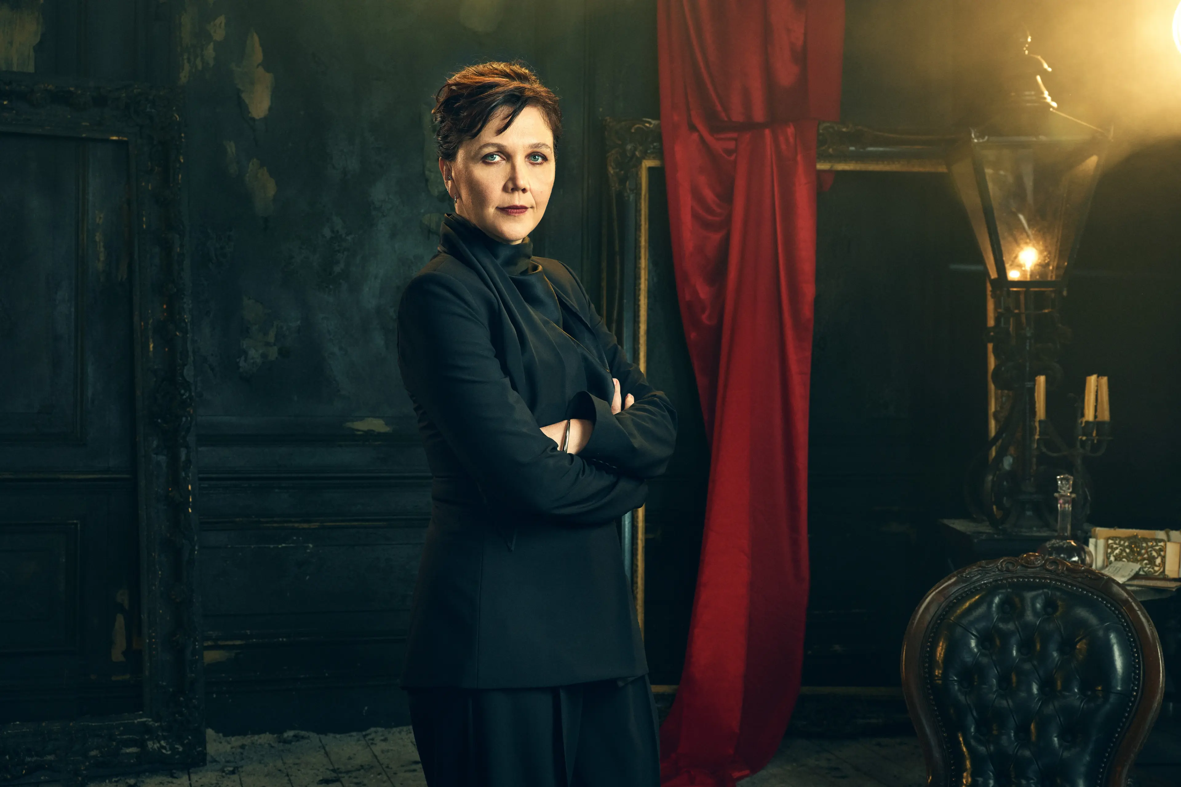 Maggie Gyllenhaal stands with her arms folded in an official Dracula audio-drama portrait.