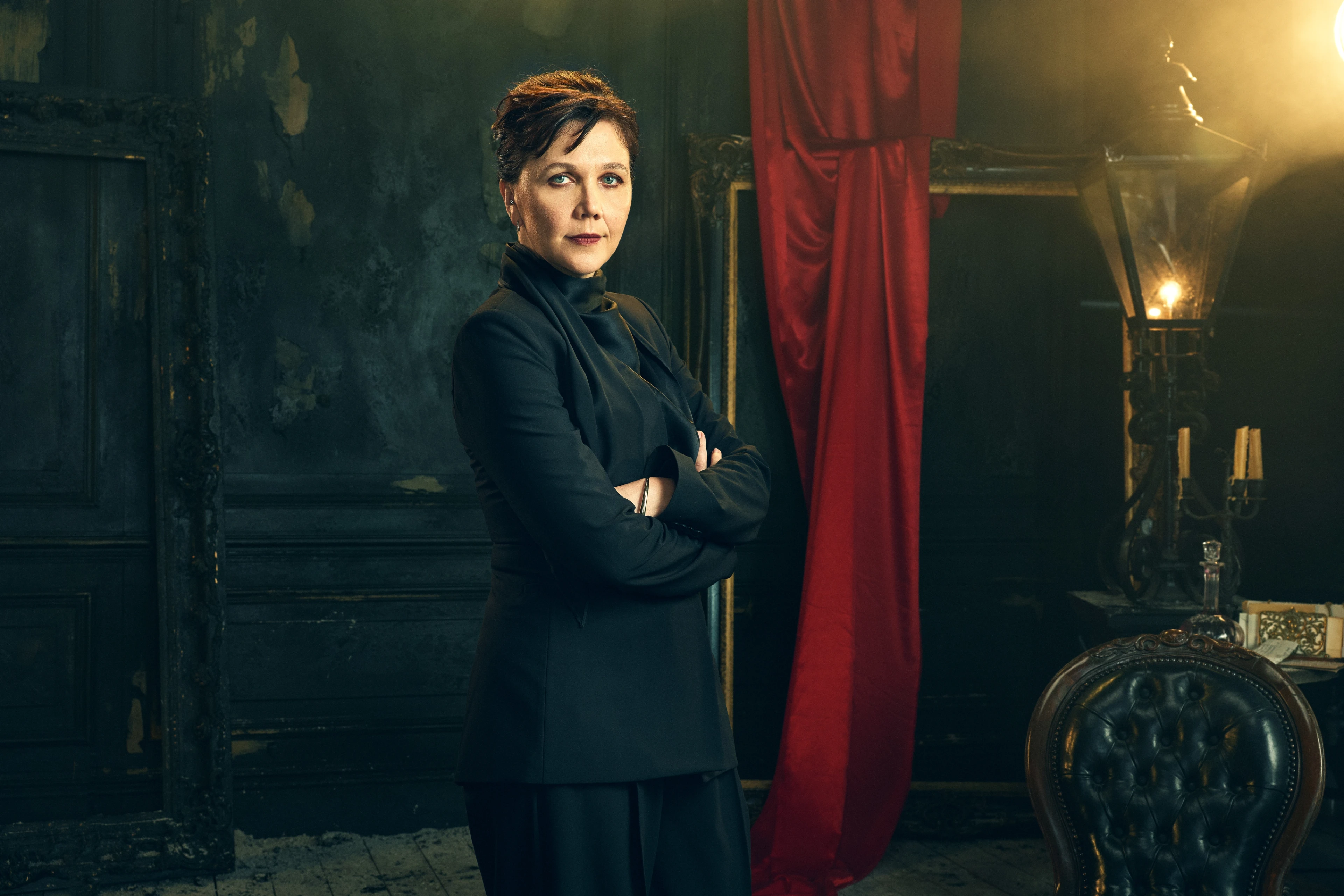 Maggie Gyllenhaal stands with her arms folded in an official Dracula audio-drama portrait.