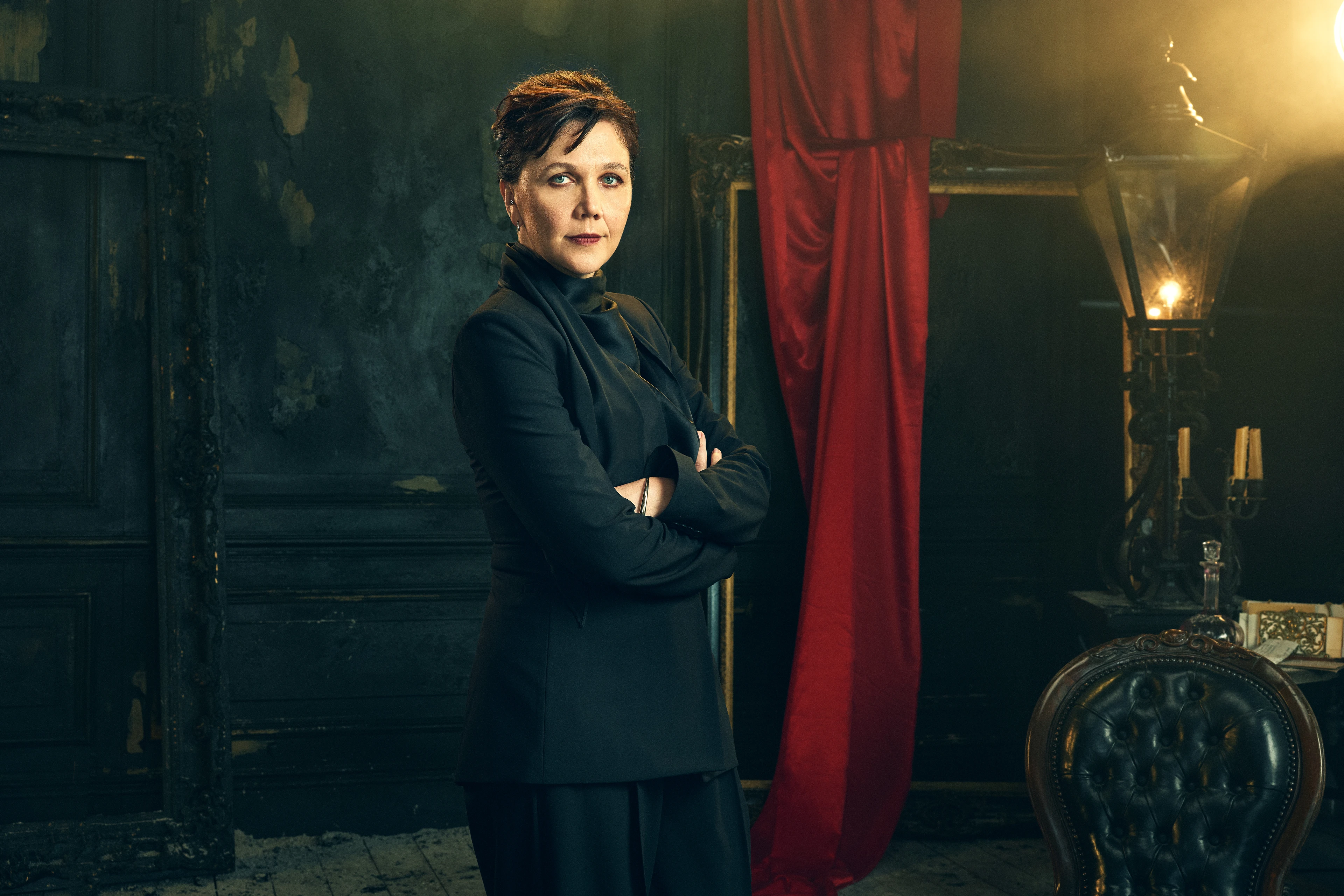 Maggie Gyllenhaal stands with her arms folded in an official Dracula audio-drama portrait.