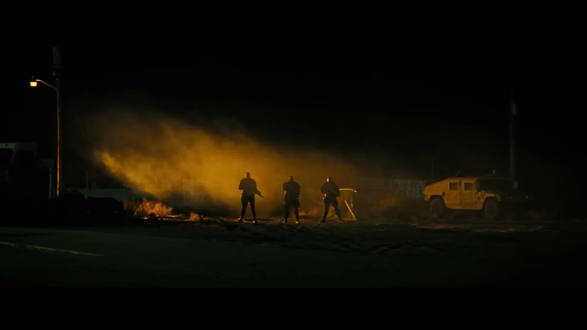 Three genetically engineered soldiers stand in the desert beside a military vehicle in Onslaught.