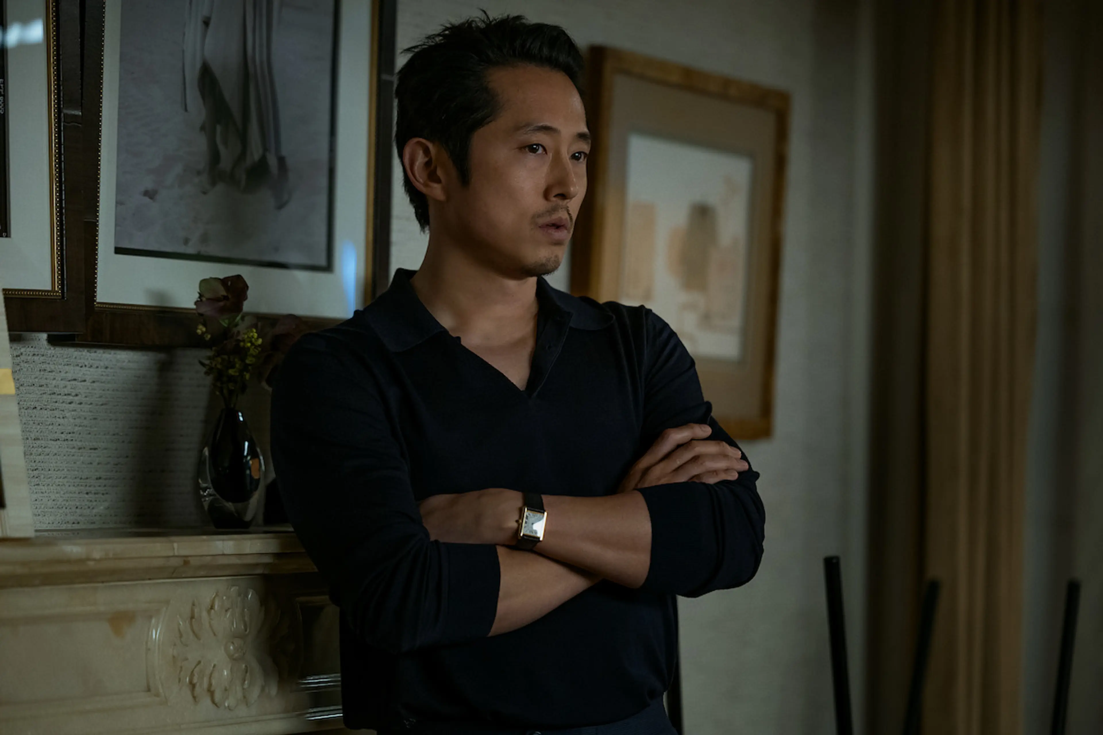 Steven Yeun stands with his arms crossed in a scene from Animals.