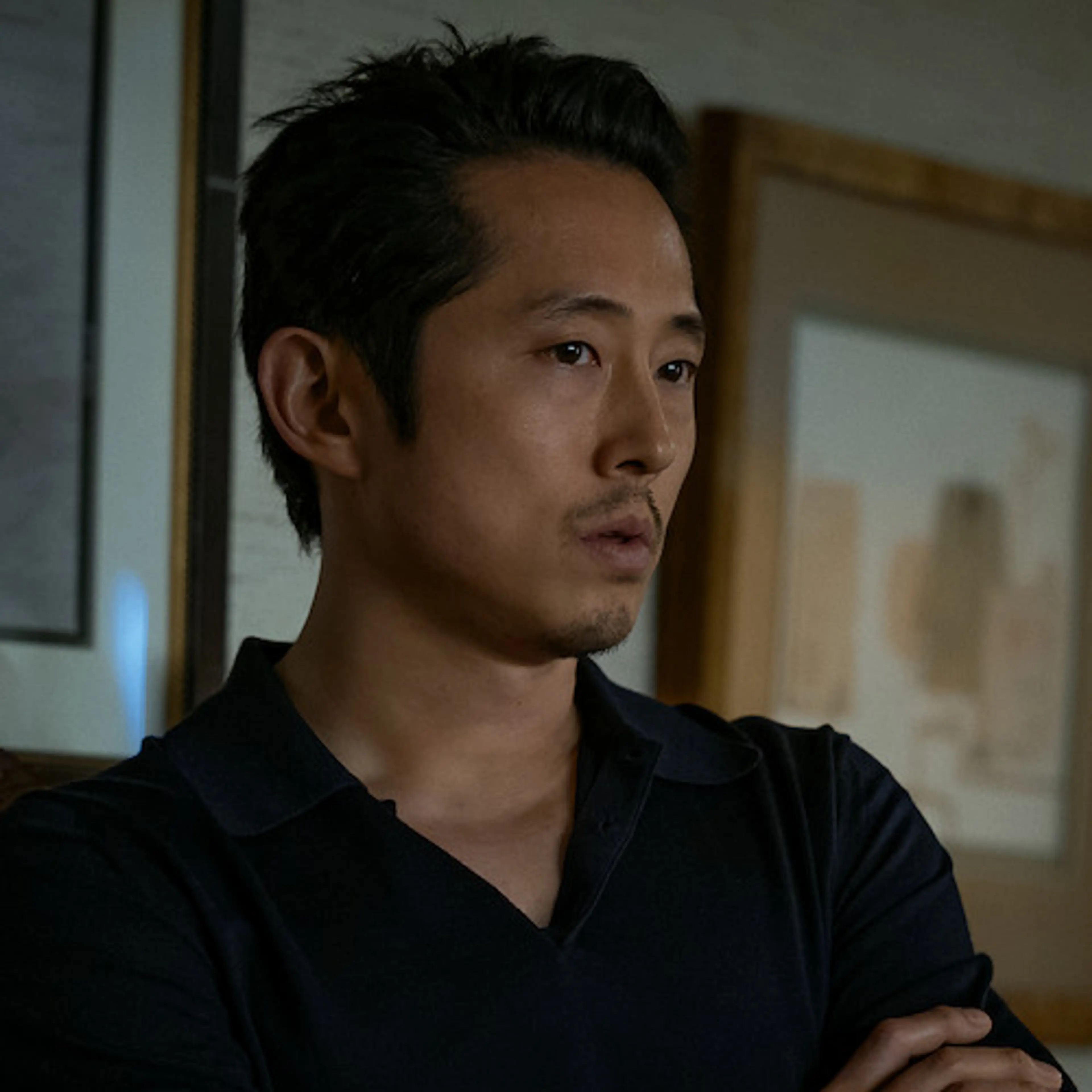Steven Yeun in a black shirt in an official Animals production photograph.