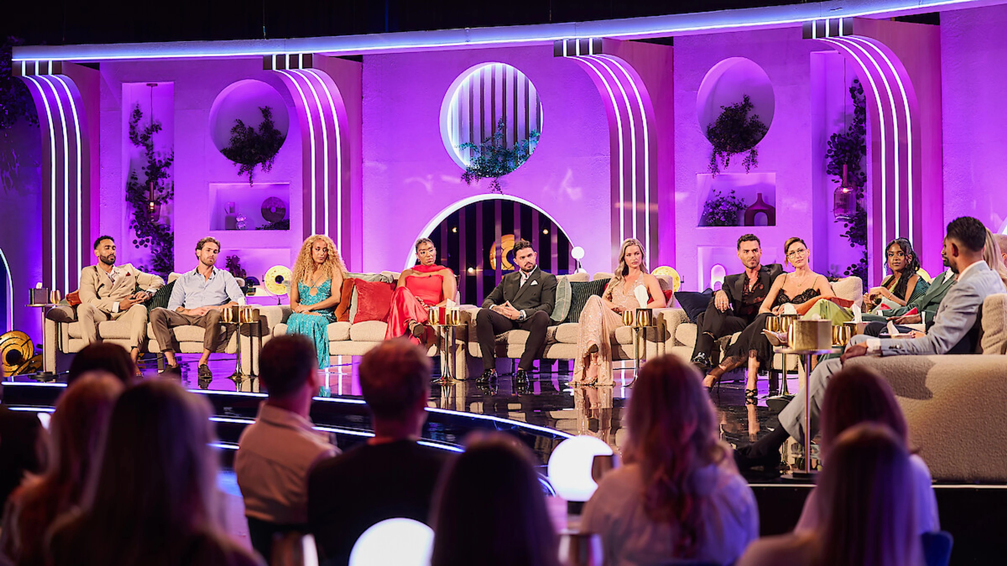 The Love Is Blind UK Season 3 cast sits across the purple-lit reunion stage.