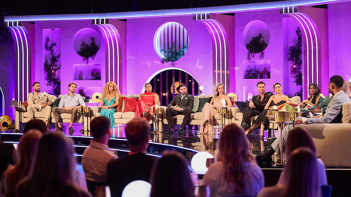 The Love Is Blind UK Season 3 cast sits across the purple-lit reunion stage.
