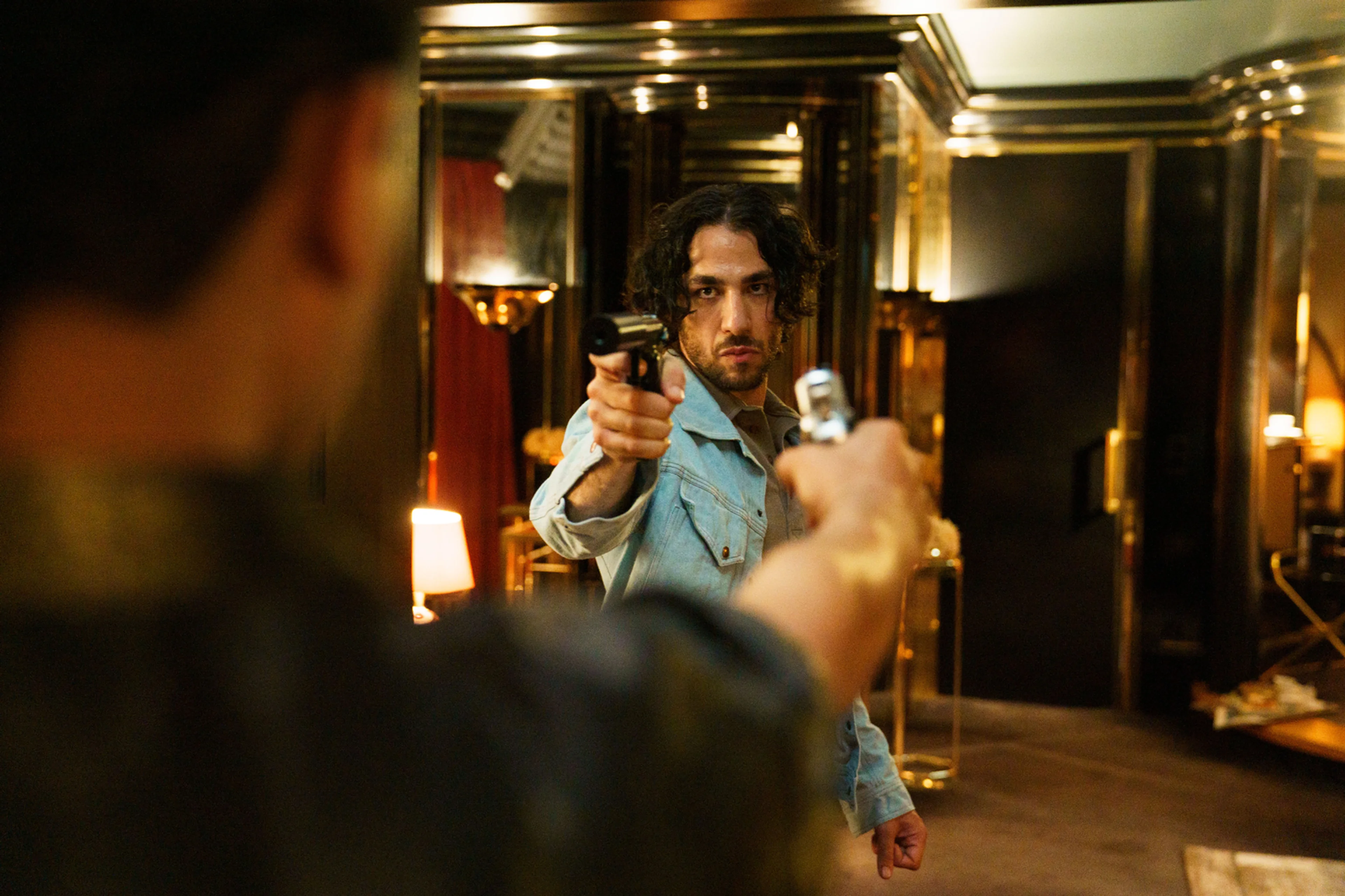 A man holds a handgun inside a mirrored room in an official 4 Blocks Zero Season 1 still.