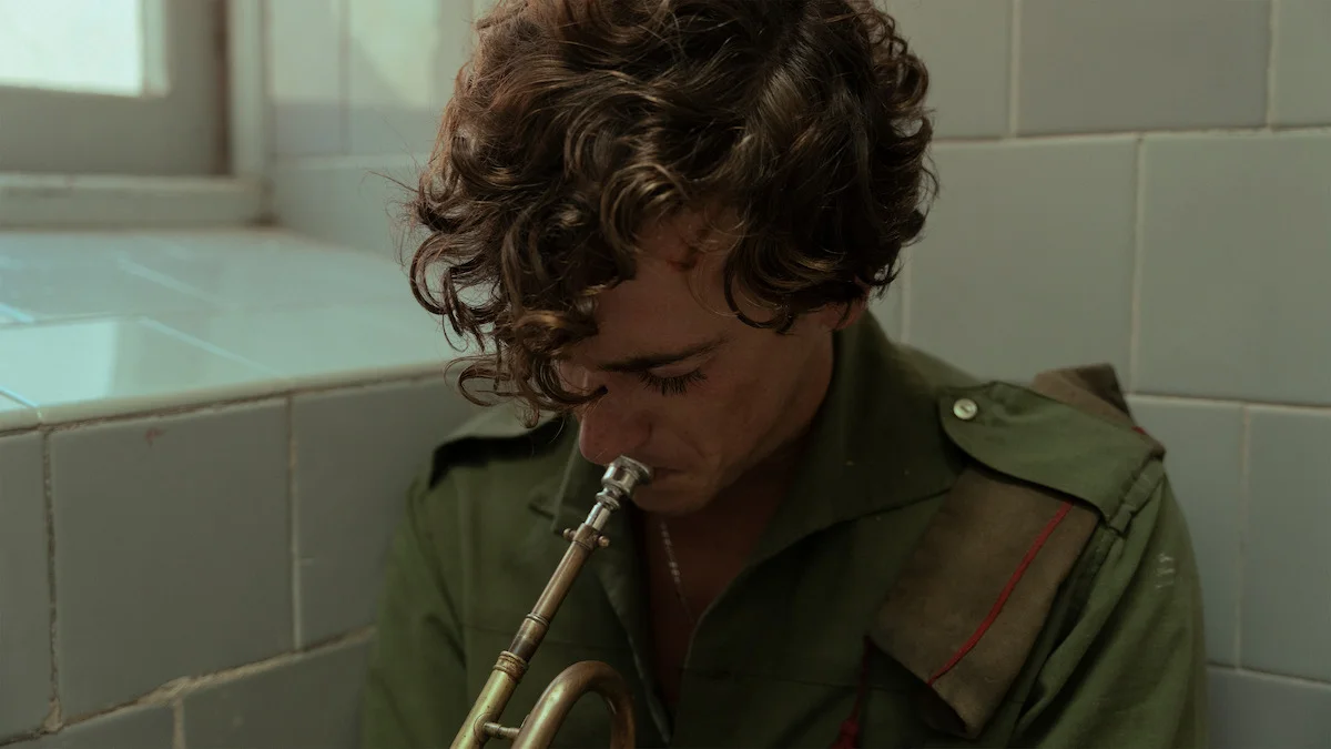 A soldier plays trumpet in La Bola Negra.