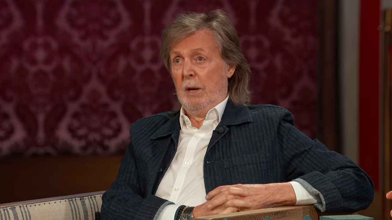 Paul McCartney looks toward Jimmy Kimmel while listening to his bathroom story.