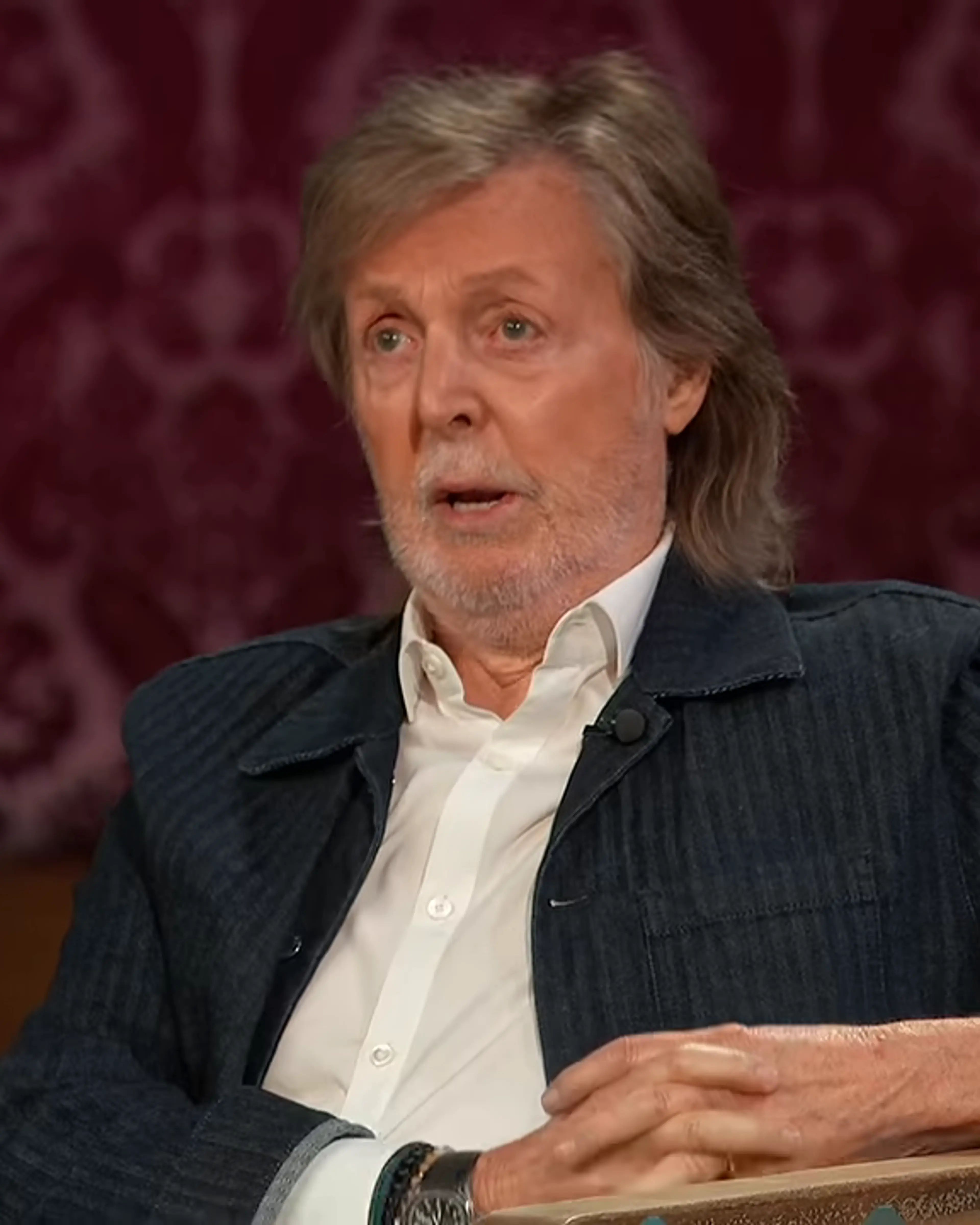 Paul McCartney looks toward Jimmy Kimmel while listening to his bathroom story.