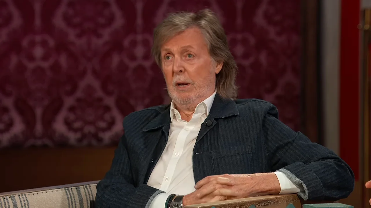 Paul McCartney looks toward Jimmy Kimmel while listening to his bathroom story.