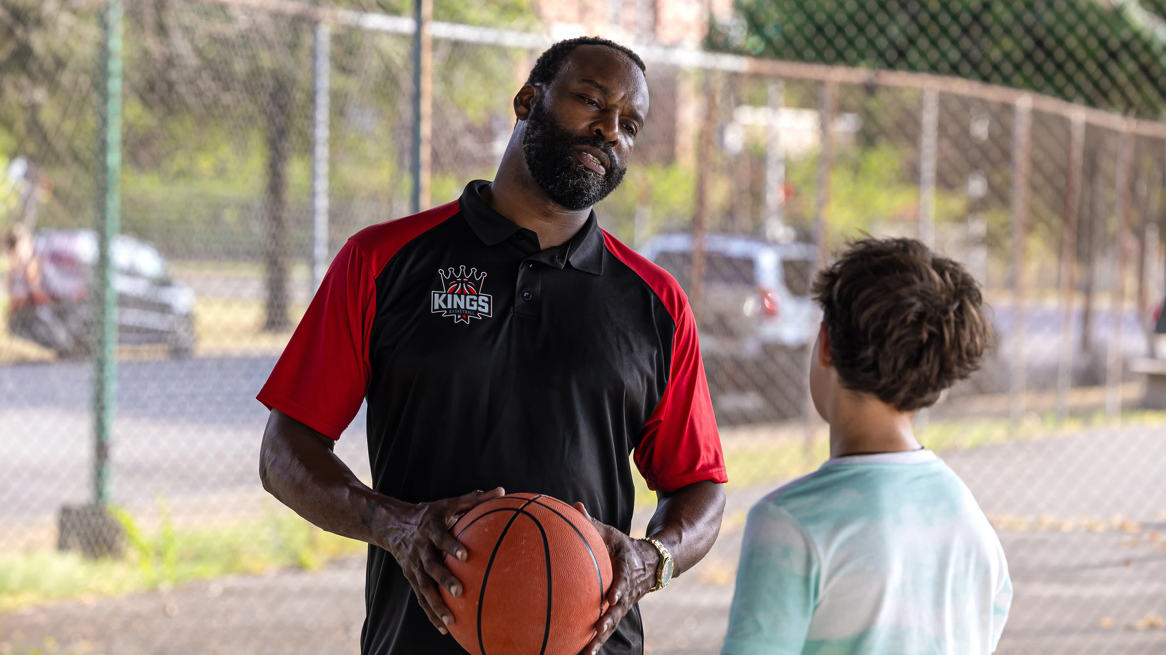 Baron Davis holds a basketball beside Dylan Friedman on an outdoor court in Last Shot.
