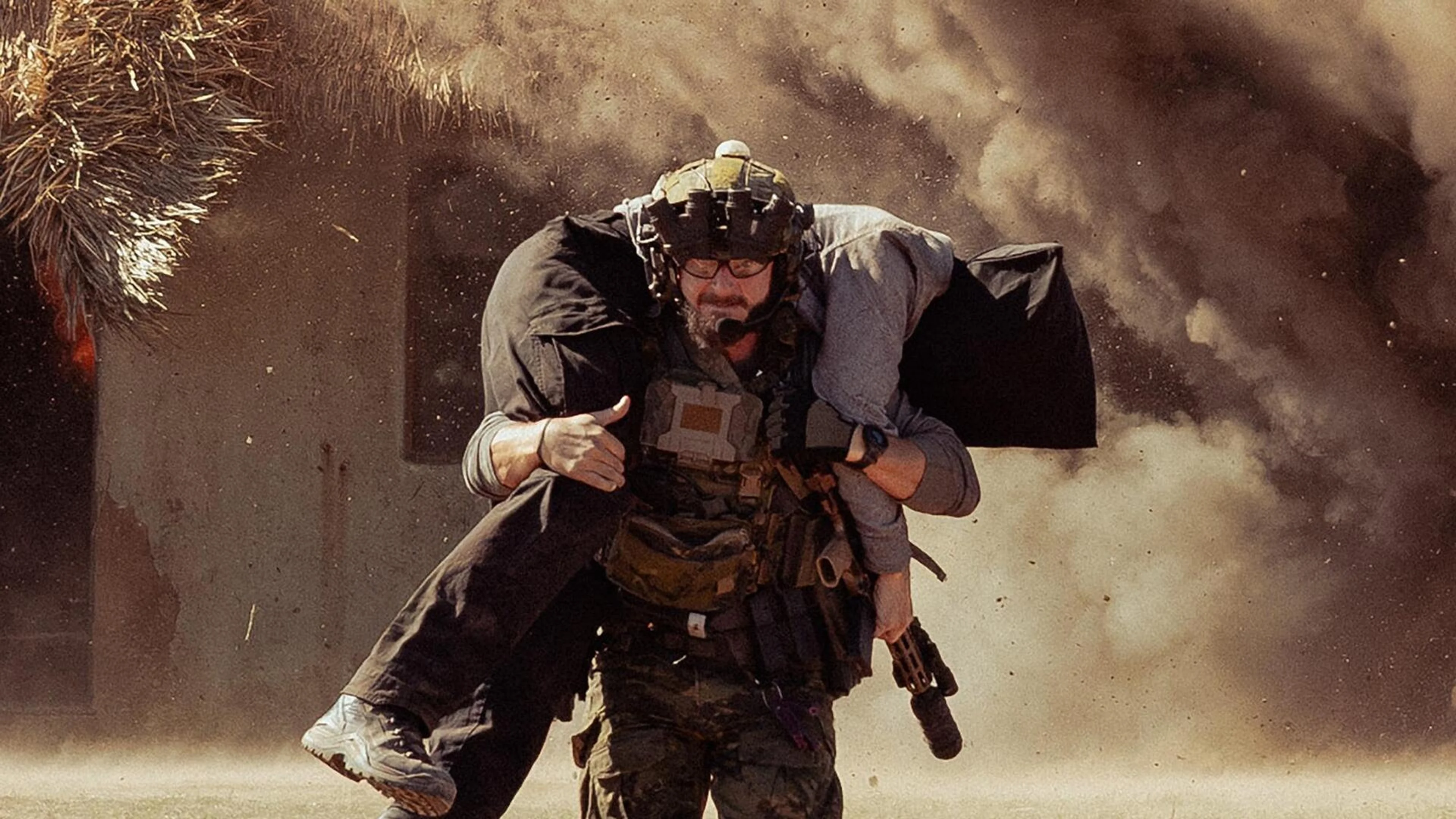 An operative carries another person away from an explosion in the Lioness Season 3 premiere.