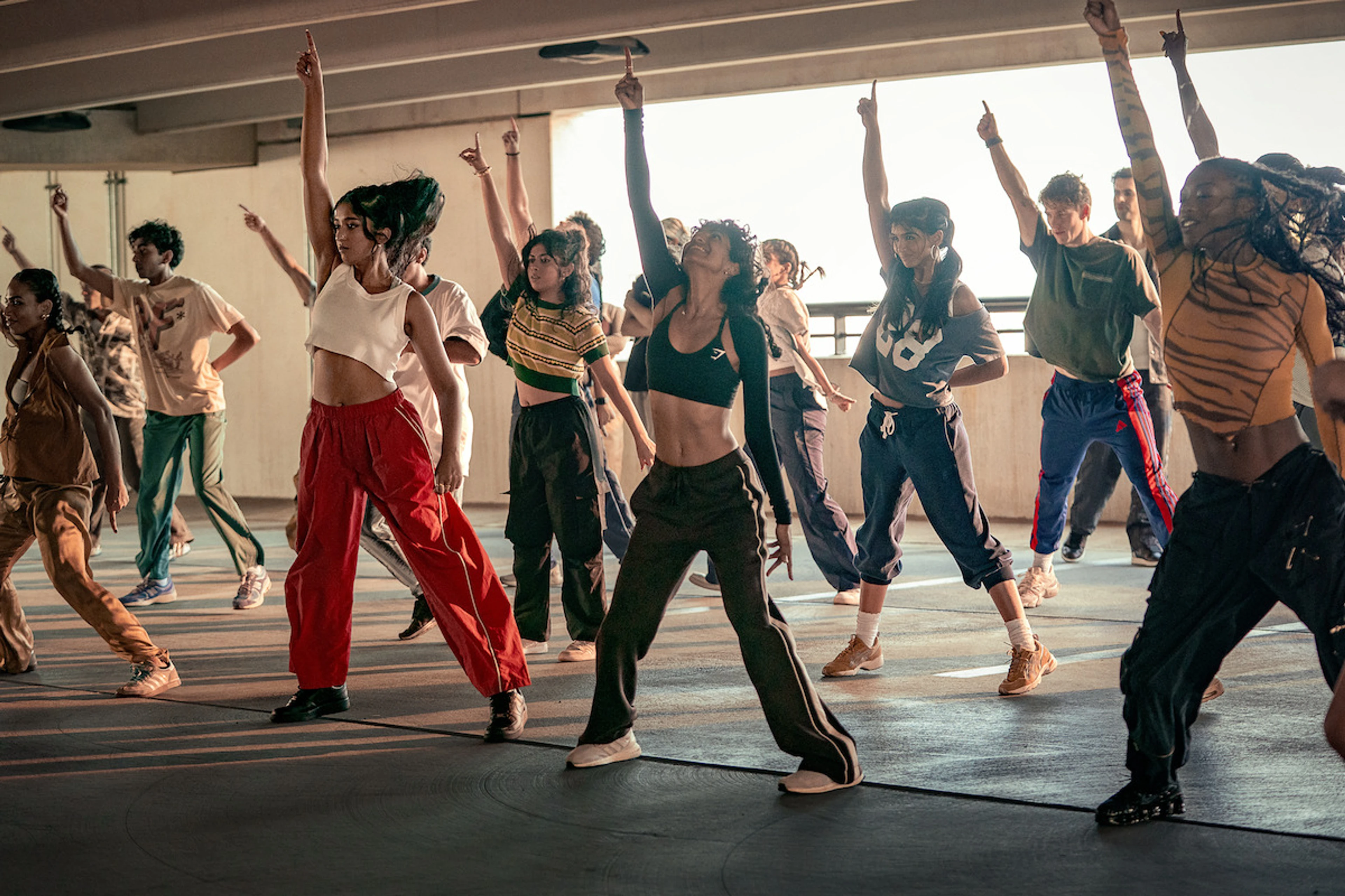 A college dance team strikes a pose while rehearsing together.