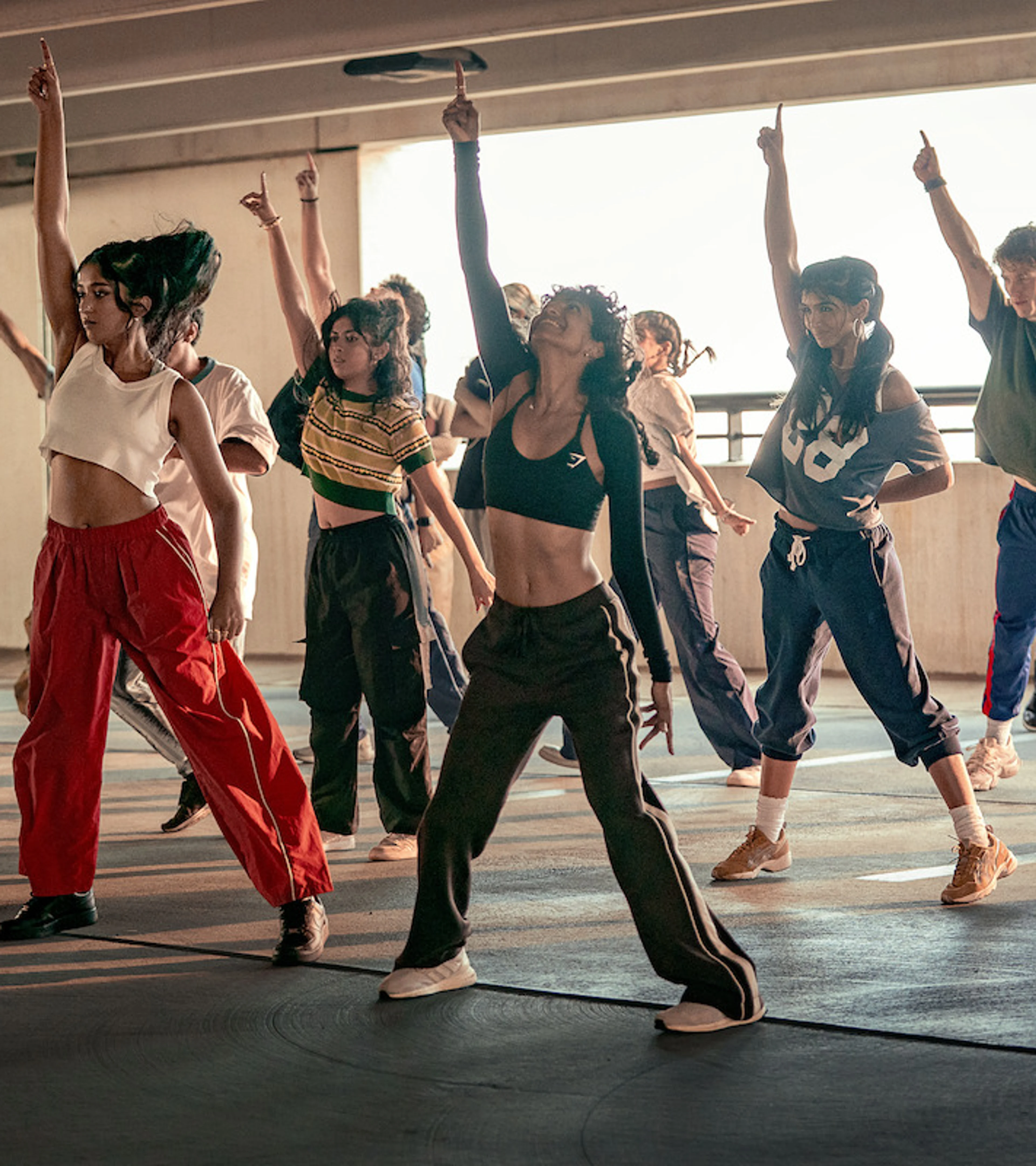 A college dance team strikes a pose while rehearsing together.