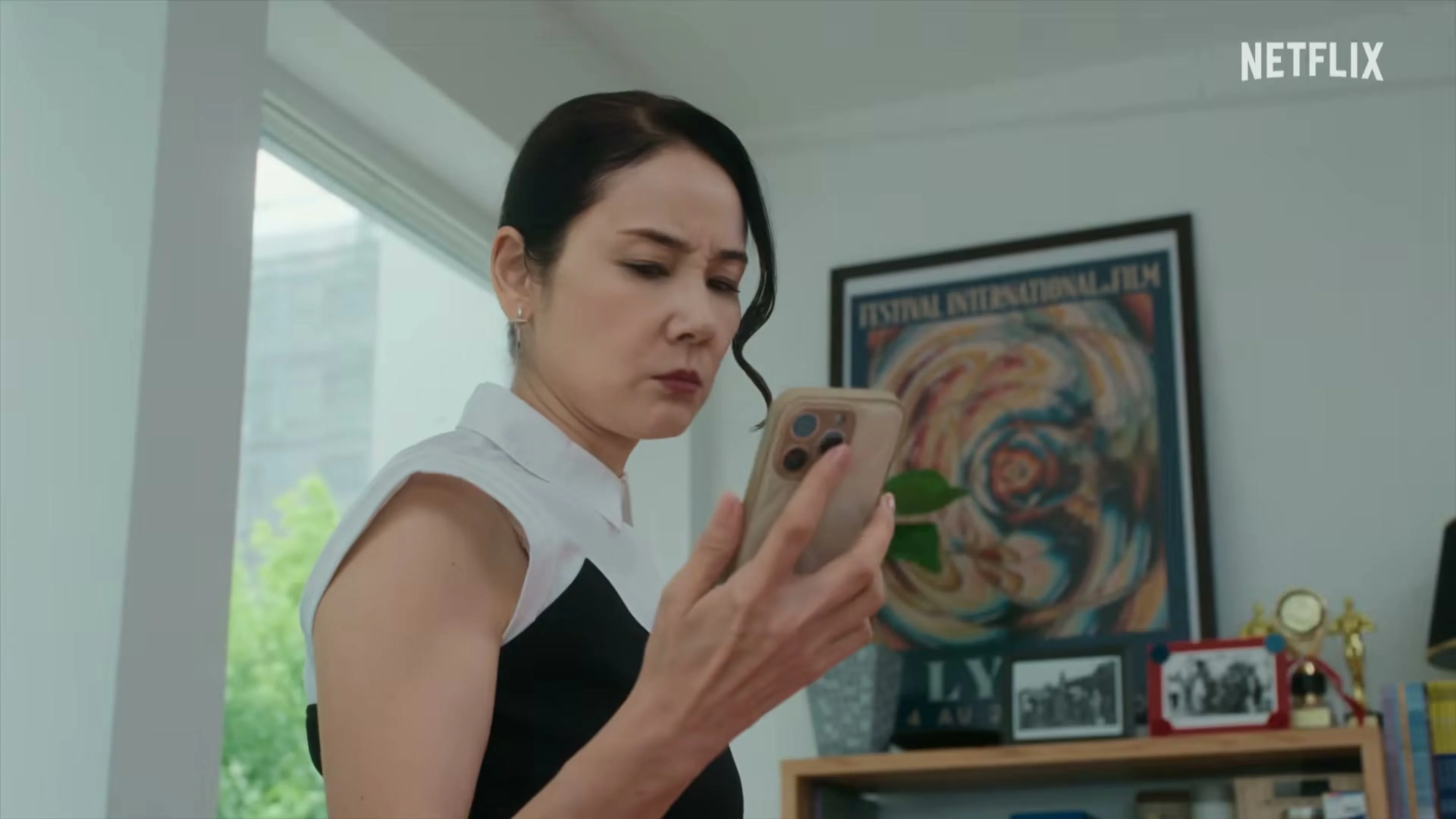 Yoh Yoshida as agency head Yoko Nonomura looks at a phone.