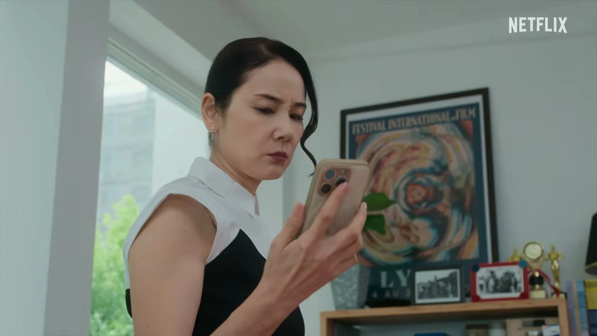 Yoh Yoshida as agency head Yoko Nonomura looks at a phone.