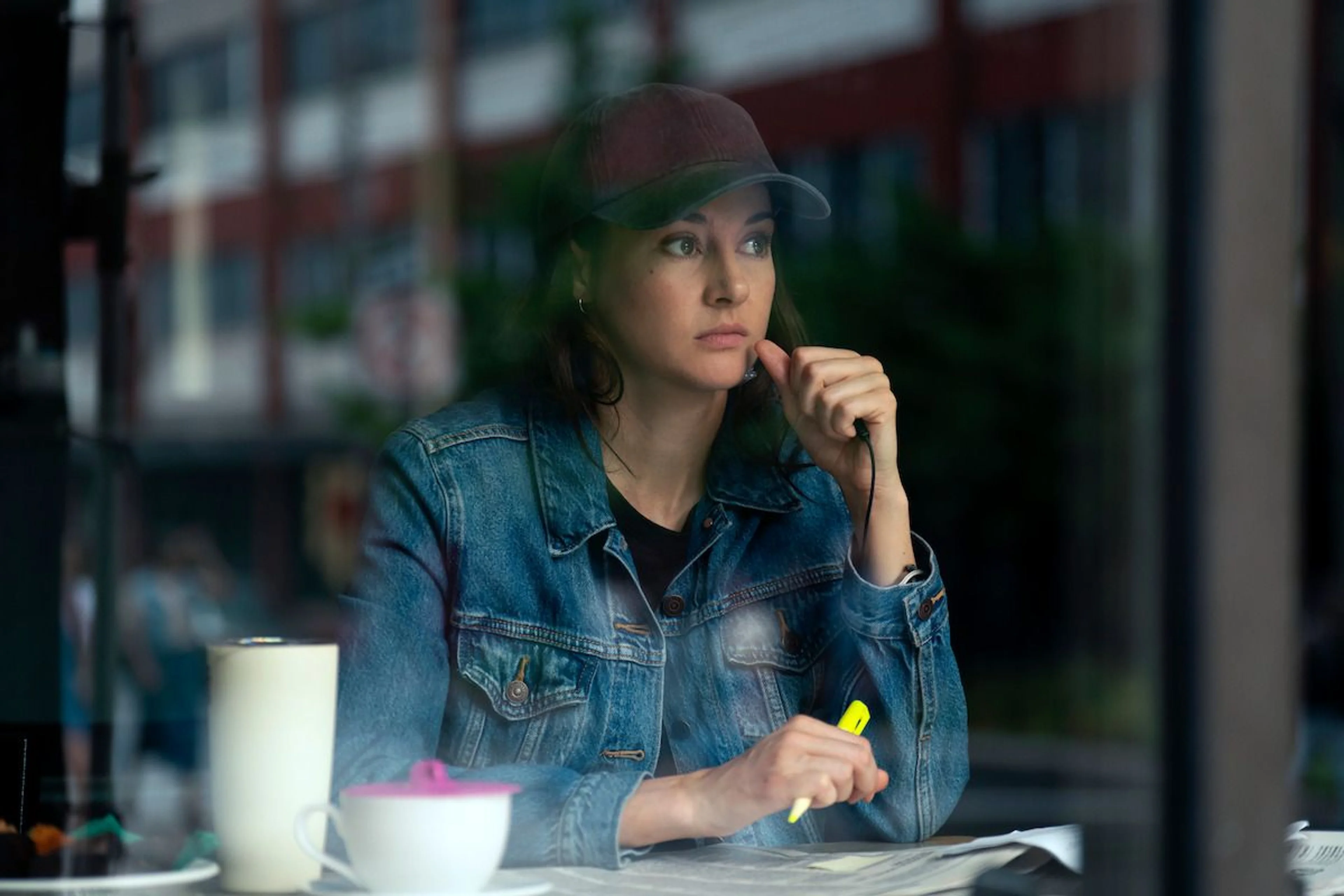 Shailene Woodley as Joanne Miller studies papers in a cafe in UNABOMBER.