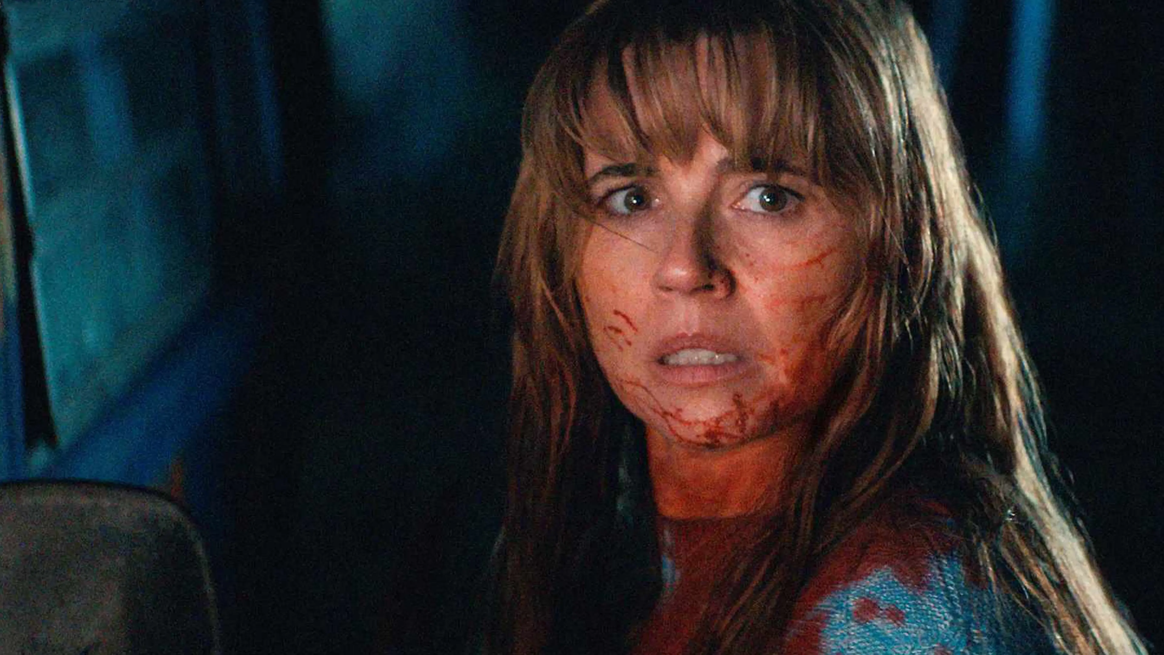 Linda Cardellini as Pamela Voorhees sits bloodied inside a car in Crystal Lake.