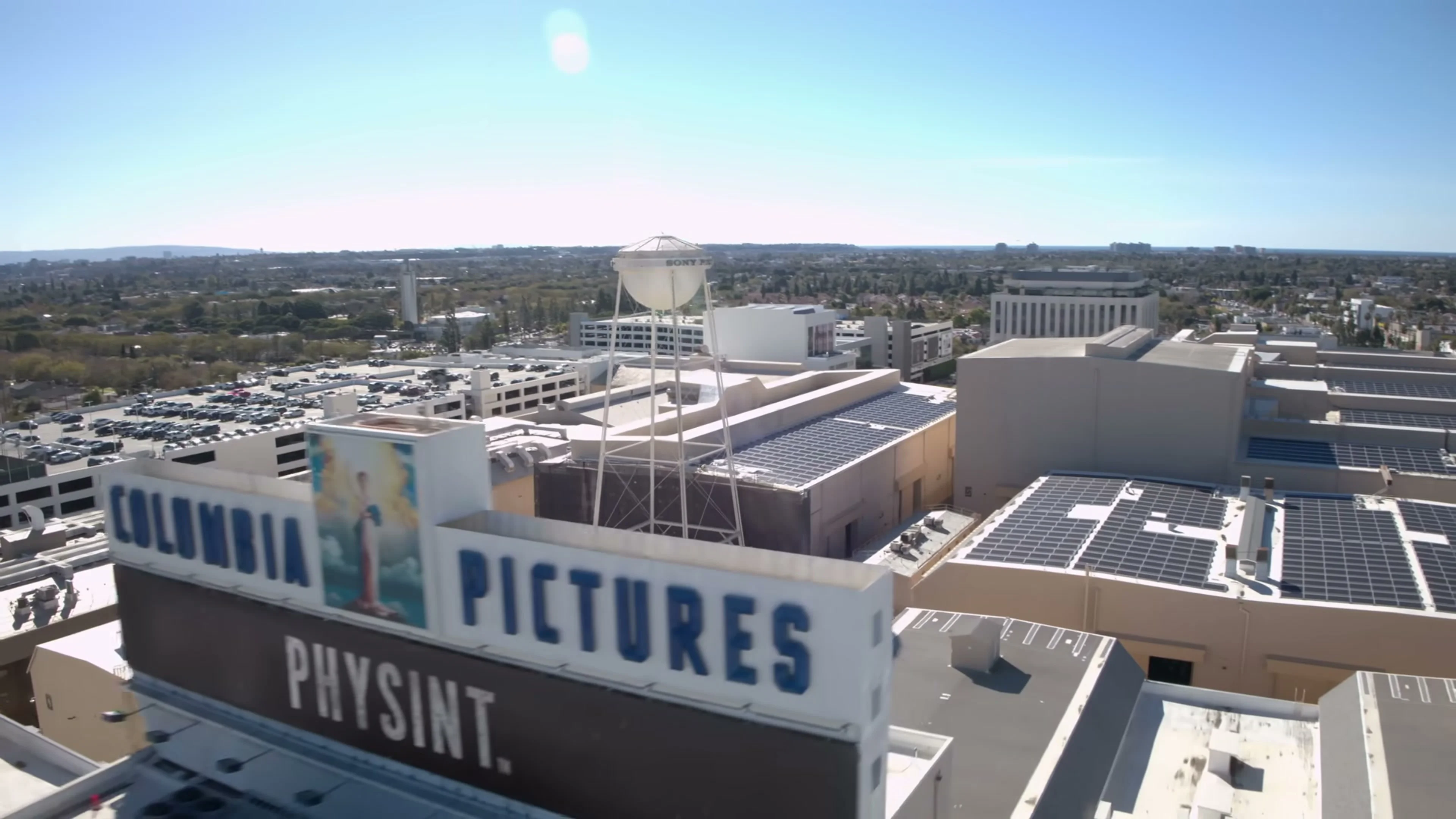 An aerial view of the Columbia Pictures lot shows the PHYSINT name beneath its entrance sign.