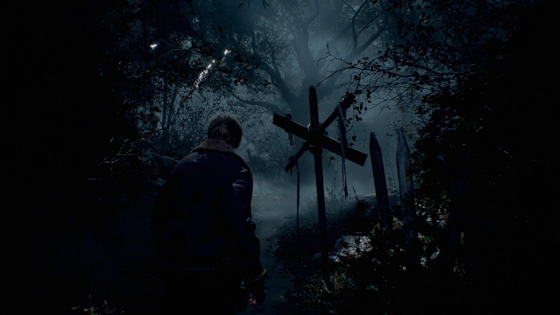 Leon S. Kennedy walks down a dark wooded path.