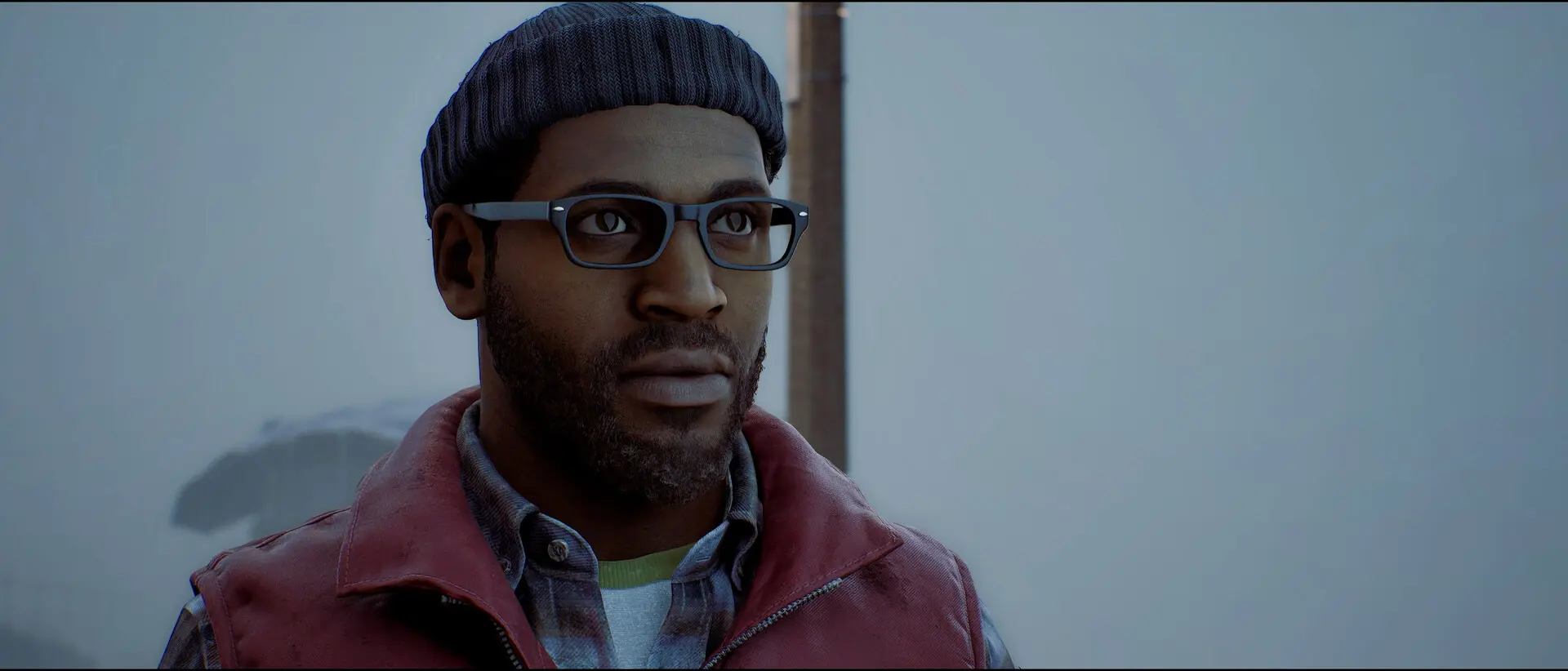 Simon Ordell wears glasses, a knitted hat and a red jacket in a foggy street.