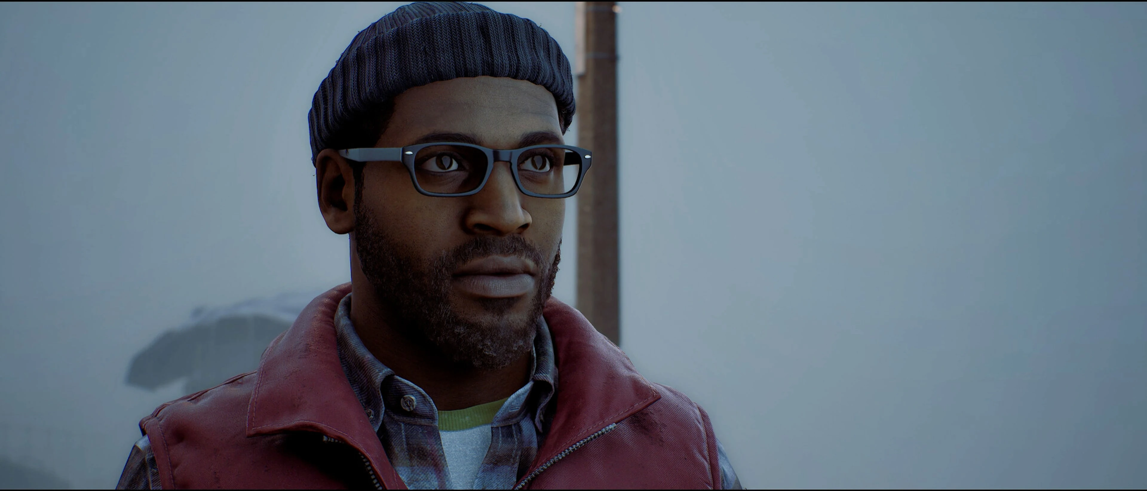 Simon Ordell wears glasses, a knitted hat and a red jacket in a foggy street.