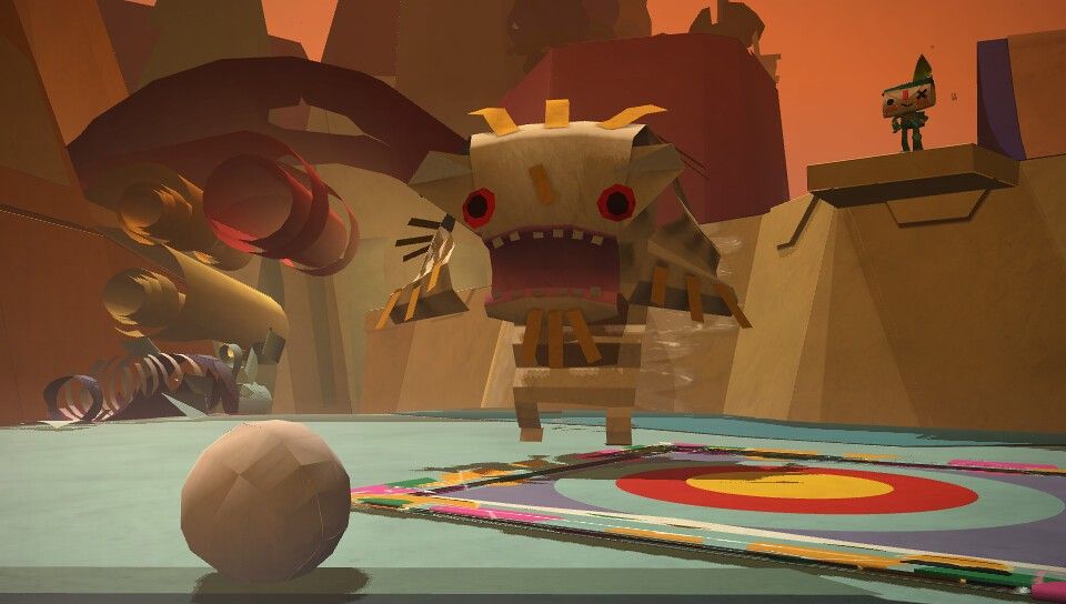 A large paper creature stands beside a colored circular floor while the messenger waits on a platform.