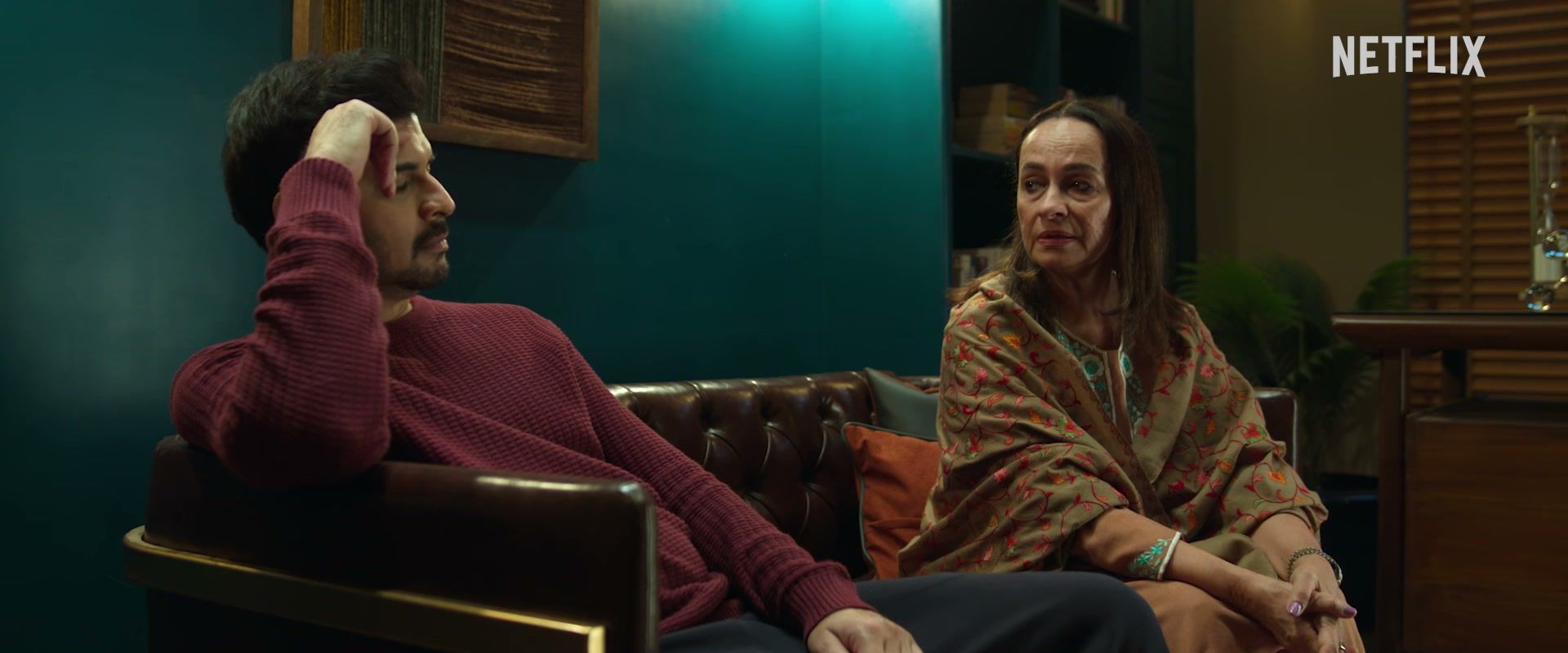 Soni Razdan as Madhu sits beside Tahir Raj Bhasin as her son Alok, who rests a hand against his head.