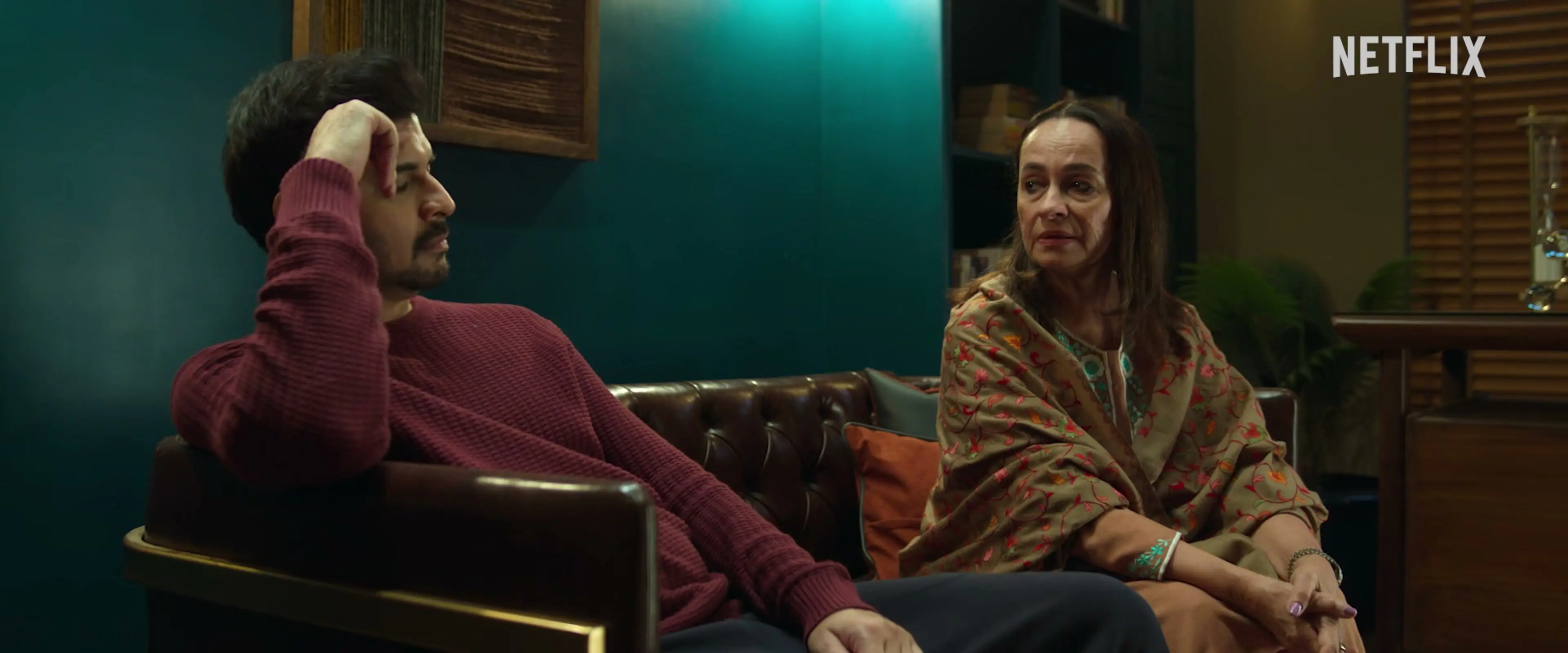 Soni Razdan as Madhu sits beside Tahir Raj Bhasin as her son Alok, who rests a hand against his head.